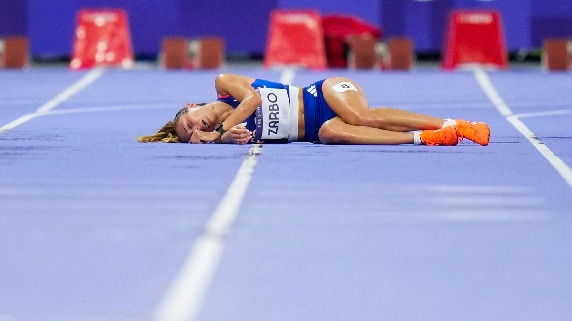 Alessia Zarbo liegt beim 10.000-Meter-Lauf der Frauen am Freitag (9. August 2024) völlig erschöpft am Boden.