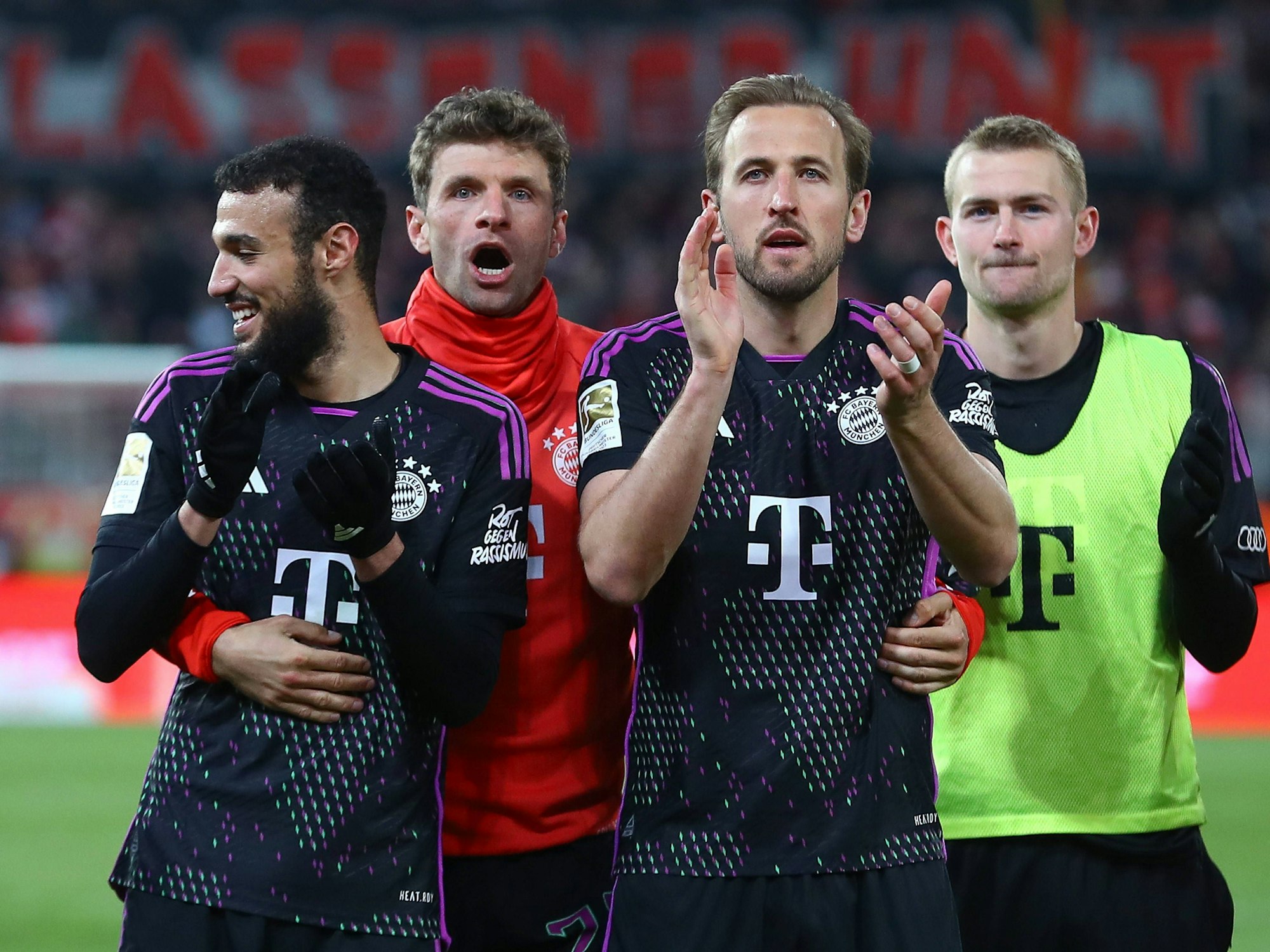 Die Bayern-Spieler Noussair Mazraoui, Thomas Müller, Harry Kane und Matthijs de Ligt bedanken sich nach dem Bundesliga-Auswärtsspiel bei Union Berlin bei den mitgereisten Fans.
