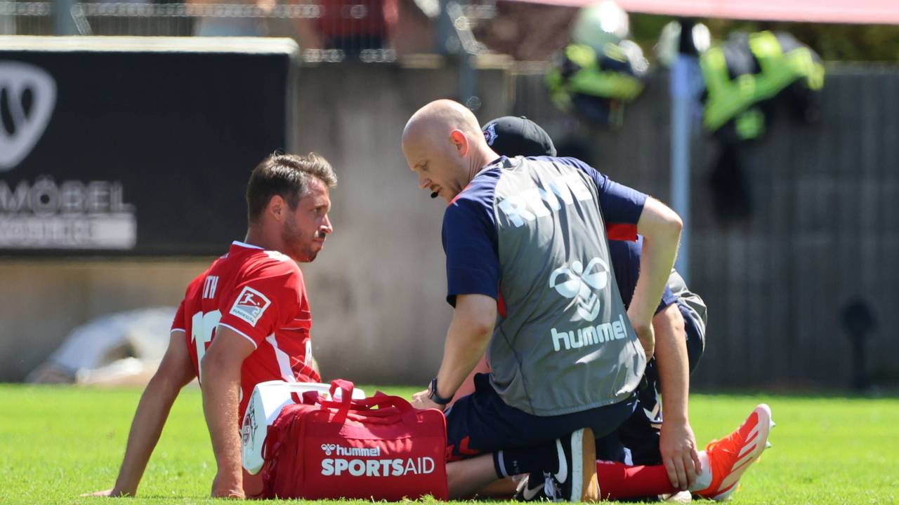 Mark Uth wird von den FC-Physios auf dem Platz behandelt.