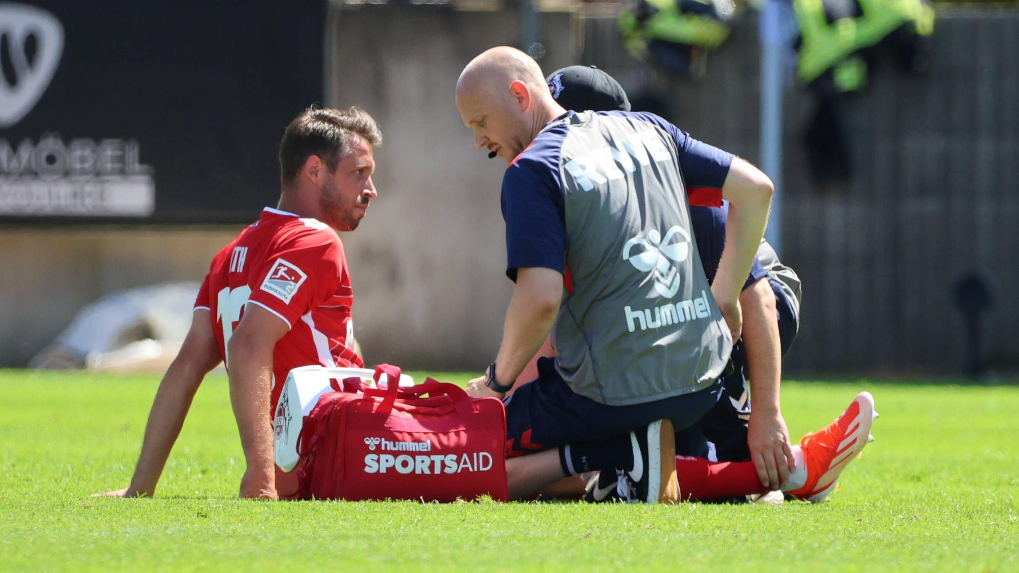 Mark Uth vom 1. FC Köln sitzt in Elversberg verletzt auf dem Rasen.