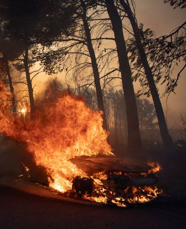 Ein Auto brennt während eines Waldbrandes im Dorf Varnava.