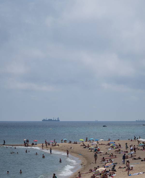 Badegäste stehen am Strand Barceloneta in Barcelona.