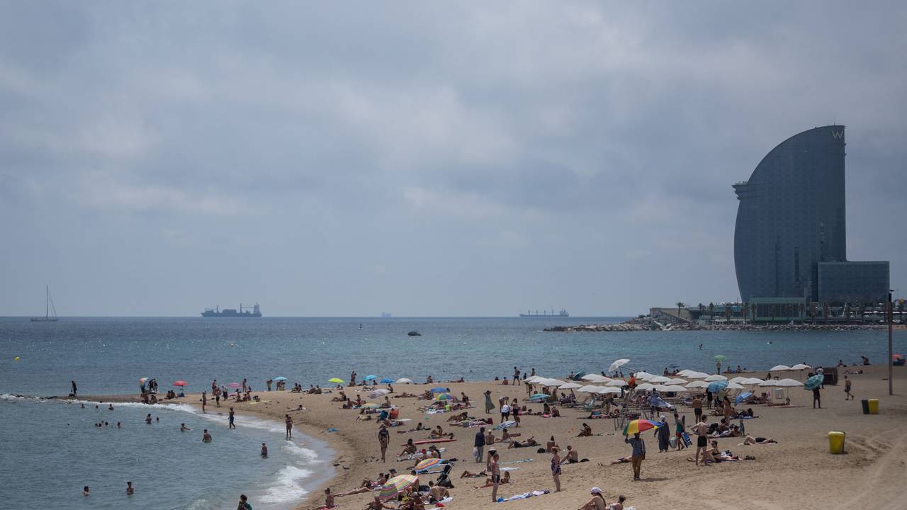 Badegäste stehen am Strand Barceloneta in Barcelona.