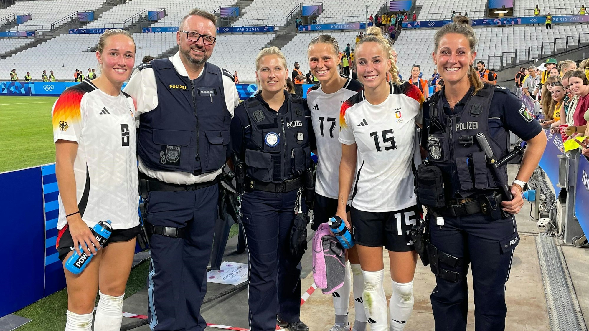 Kristina Kilb mit zwei Kollegen und den Nationalspielrinnen Guilia Gwinn, Klara Bühl und Sydney Matilda Lohmann nach dem Olympia-Auftaktspiel gegen Australien.