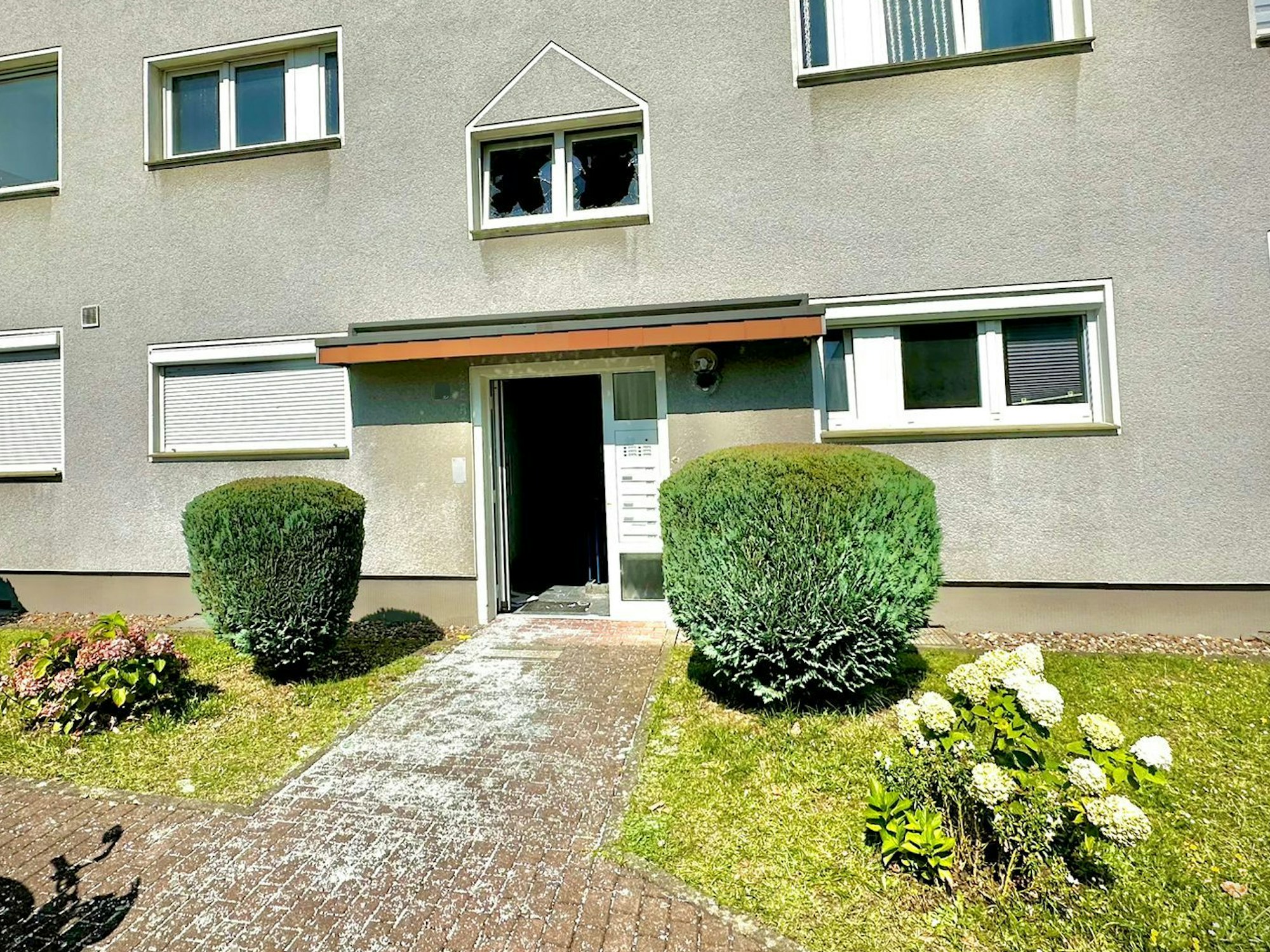 Vor diesem Mehrfamilienhaus im Dahlienweg in Köln-Zündorf kam es in der Nacht auf Montag (12. August 2024) zu einer Explosion.