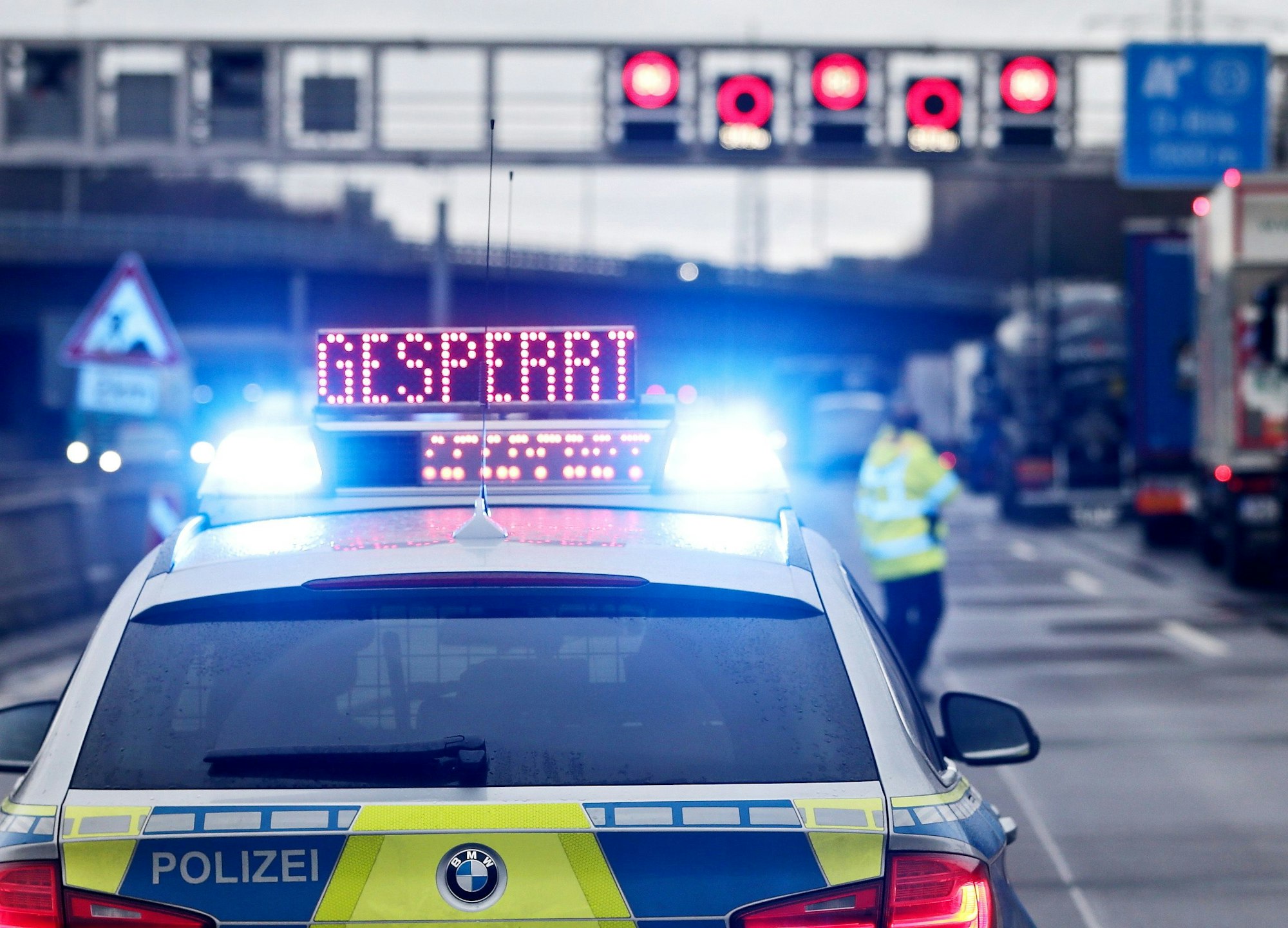 Auf einem Polizeifahrzeug leuchtet die Aufschrift 'Gesperrt'.