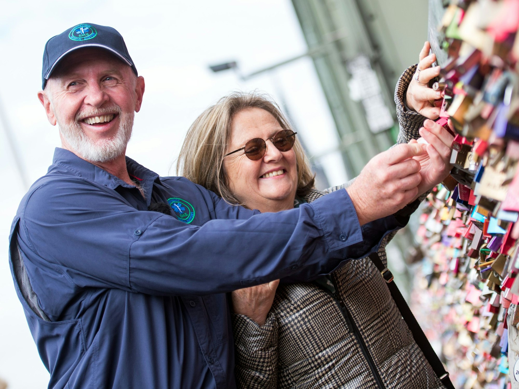 Der australische Special Effect Artist Robert „Bob“ McCarron alias Dr. Bob, bekannt aus der RTL-Show „Ich bin ein Star - Holt mich hier raus!“, und Ehefrau Annette Miles bringen am 30.07.2015 an der Hohenzollernbrücke in Köln (Nordrhein-Westfalen) ein Liebesschloss an.