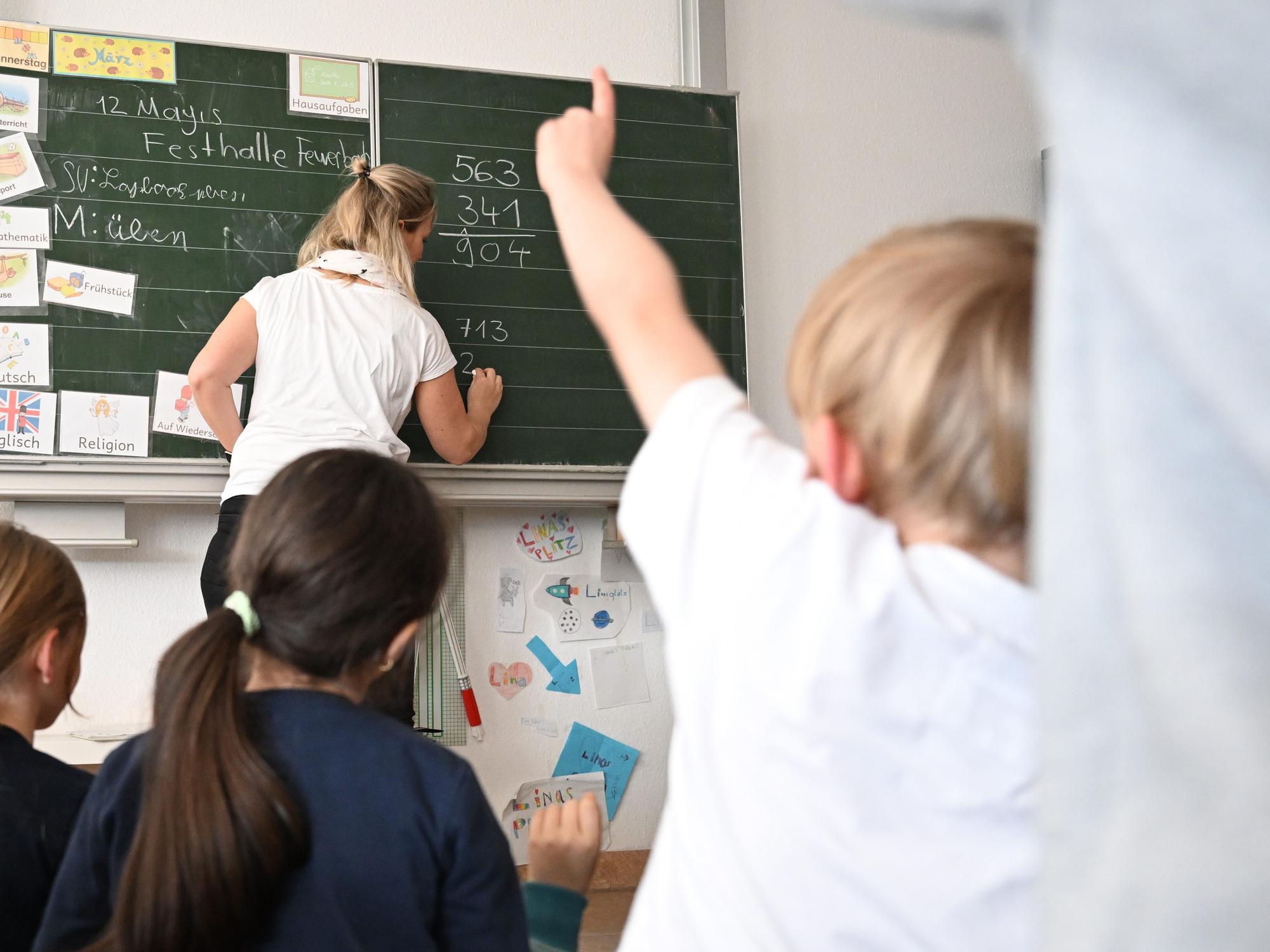 Schüler einer Grundschule arbeiten in einem Klassenzimmer an Mathematikaufgaben.