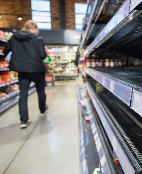 Ein Kunde des Supermarkts läuft an einem Leeren Regal, in welchem eine Dose liegt vorbei.