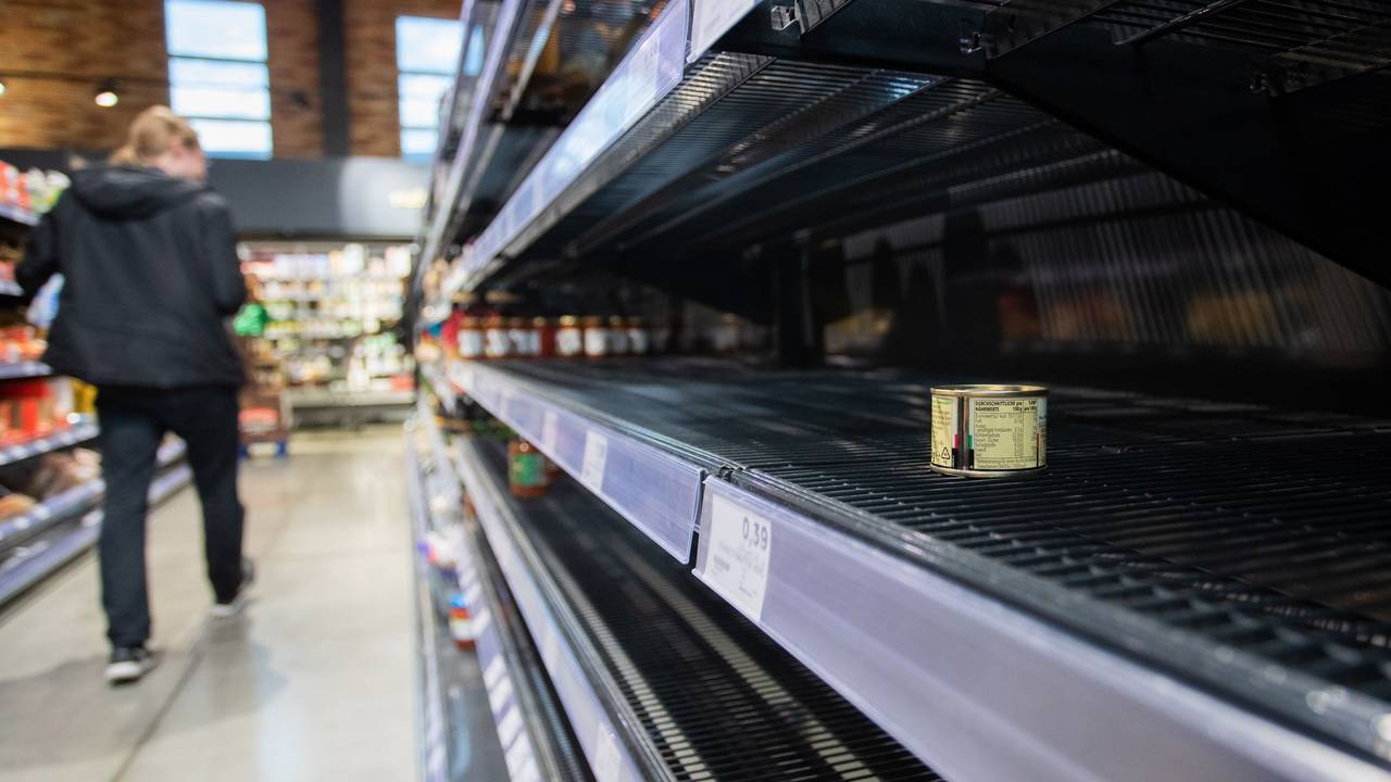Ein Kunde des Supermarkts läuft an einem Leeren Regal, in welchem eine Dose liegt vorbei.
