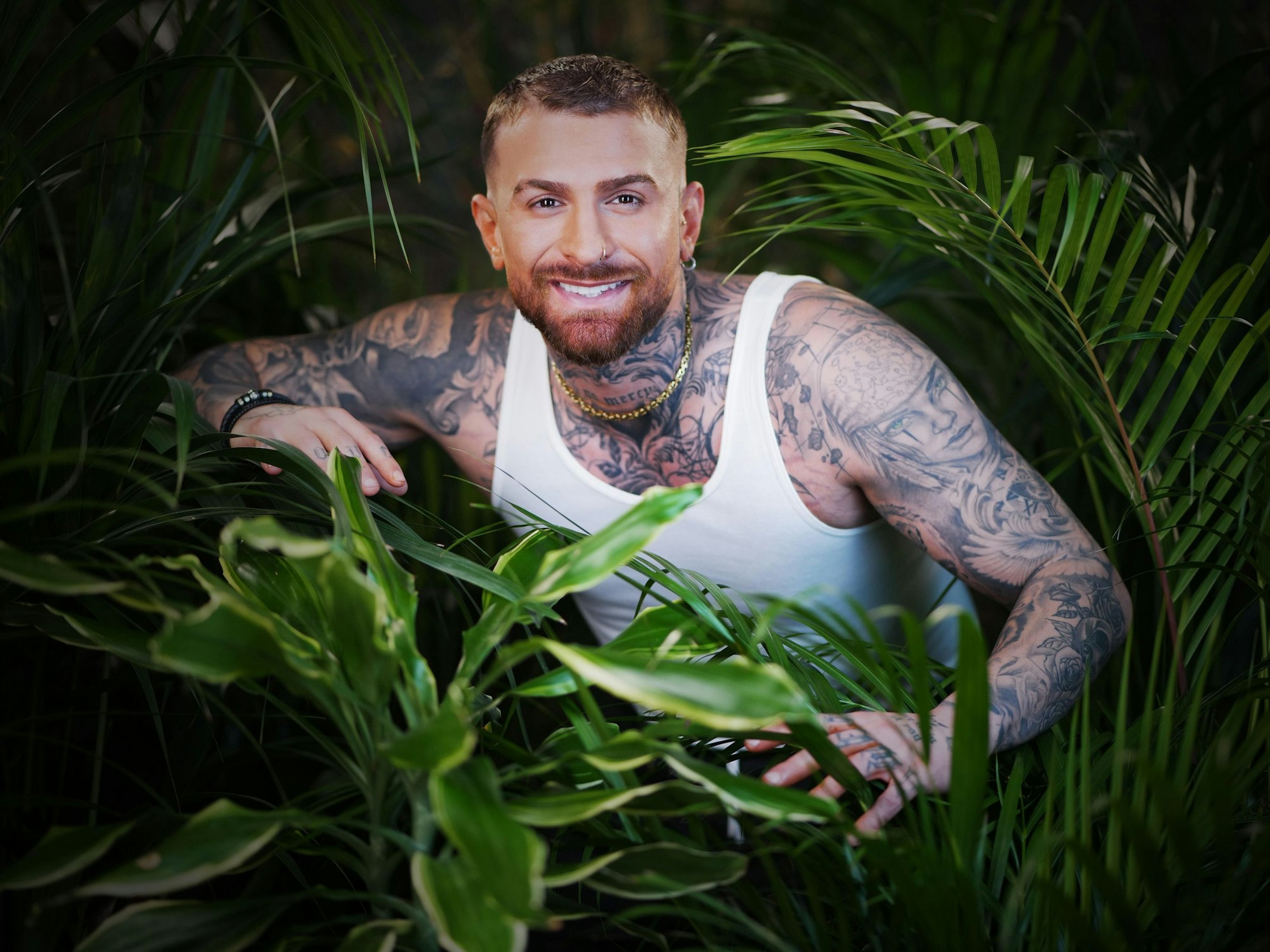 Das Foto zeigt den Sommer-Dschungelcamp-Kandidaten Gigi Birofio inmitten von Pflanzen.