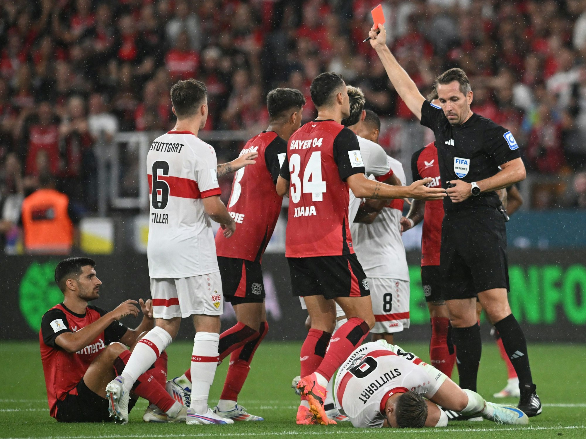 Schiedsrichter Tobias Stieler gibt eine Rote karte an Leverkusens Martin Terrier (l.).