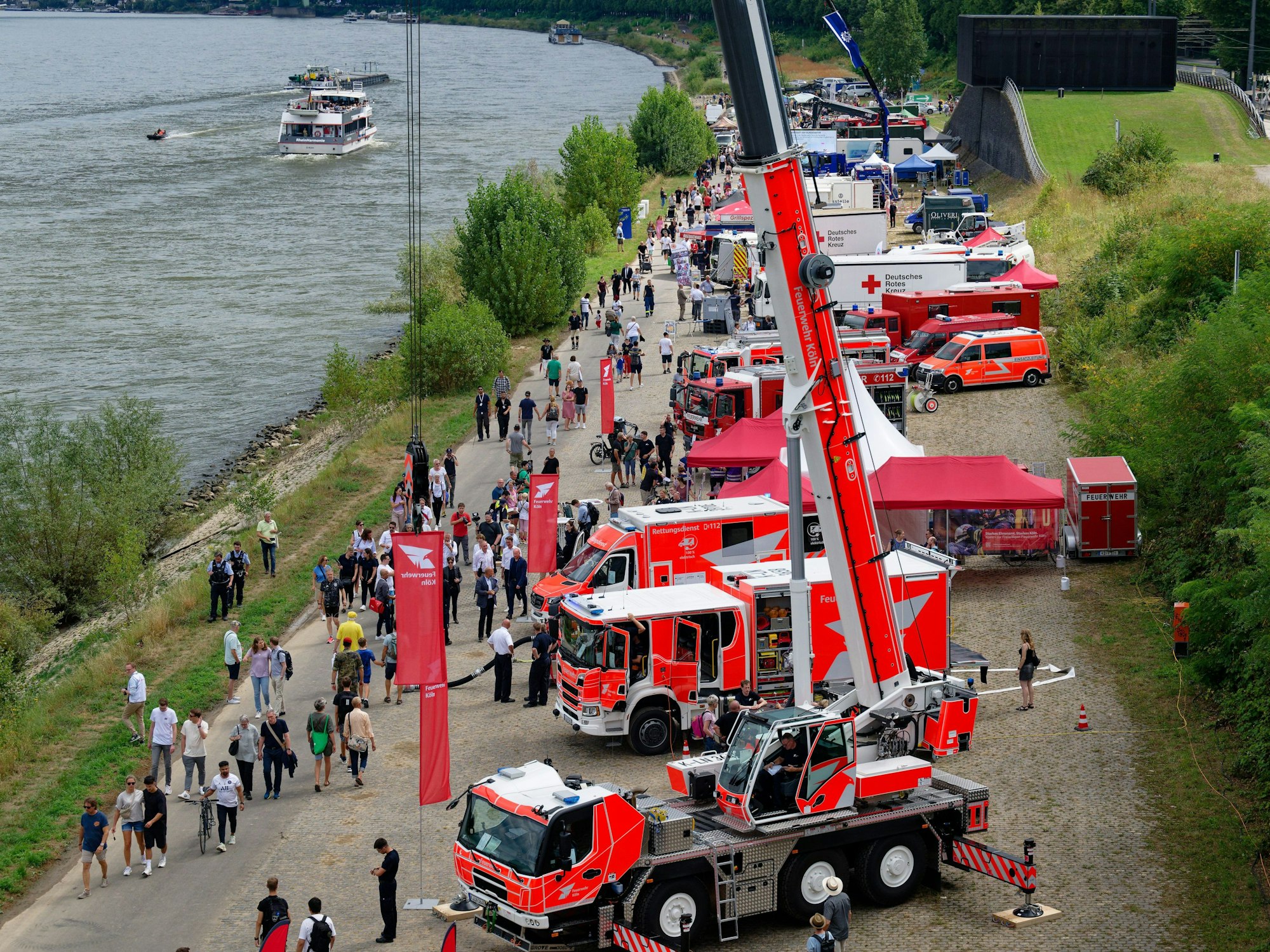 Fahrzeuge verschiedener Rettungsdienste stehen beim Nordrhein-Westfalen-Tag aufgereiht am Rheinufer.
