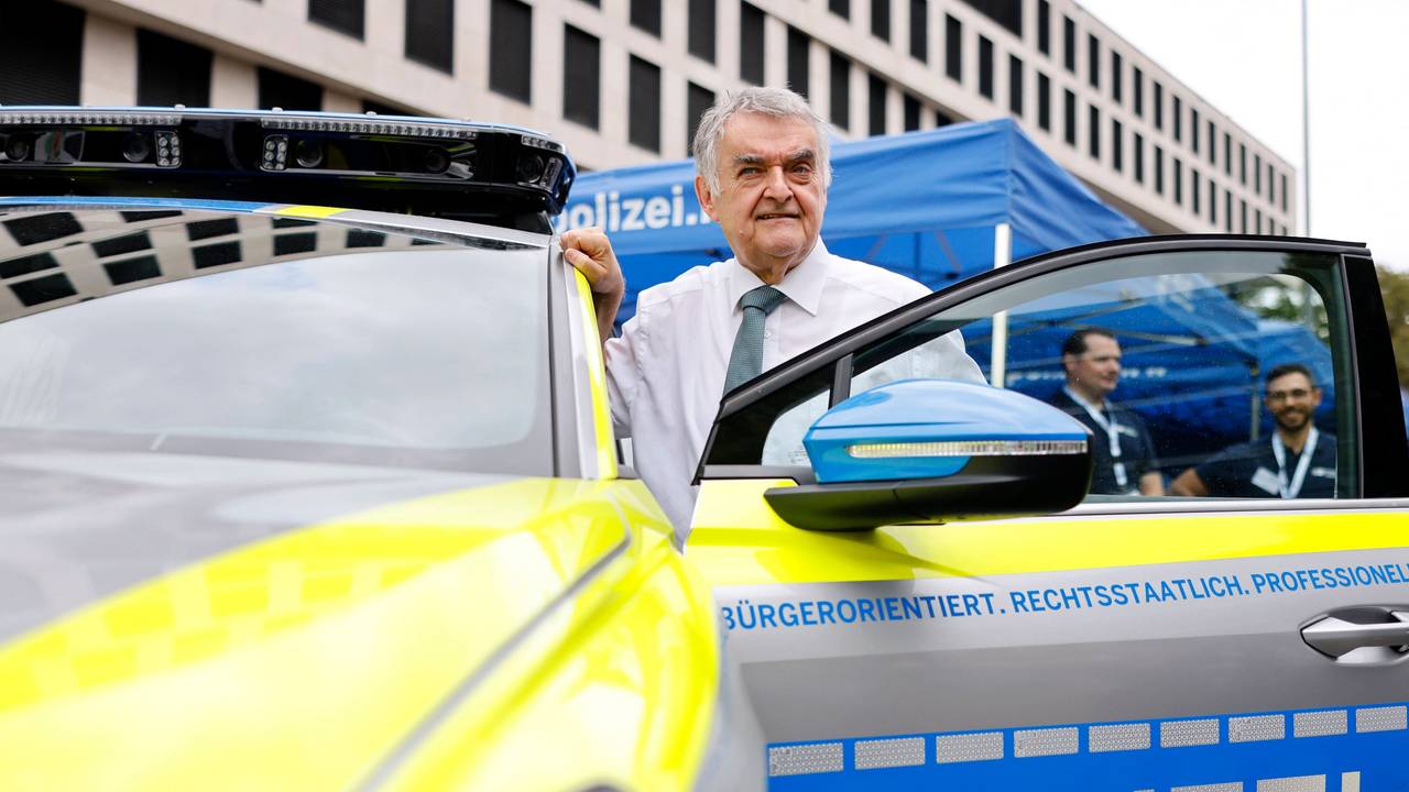 NRW-Innenminister Herbert Reul in der Fahrertür eines E-Polizei-Autos.