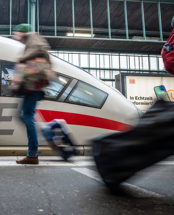 Fahrgäste laufen an einem Bahnsteig des Stuttgarter Hauptbahnhofs an einem ICE vorbei.