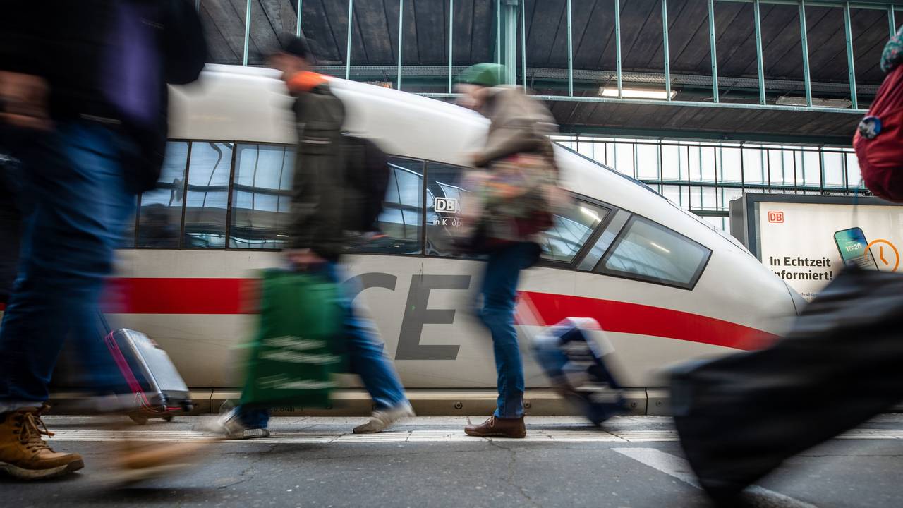 Fahrgäste laufen an einem Bahnsteig des Stuttgarter Hauptbahnhofs an einem ICE vorbei.