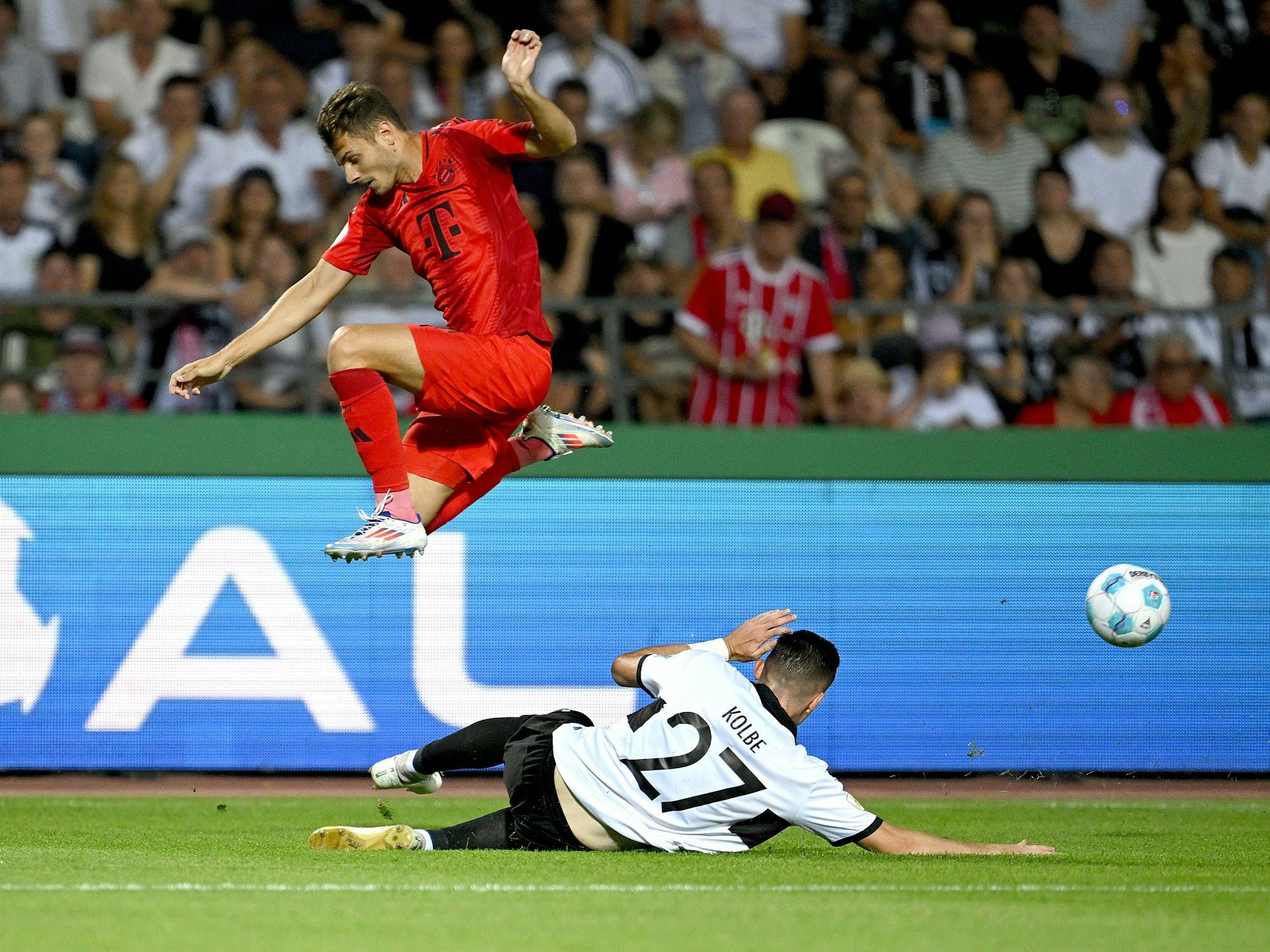 Josip Stanisic springt über Niklas Kolbe.