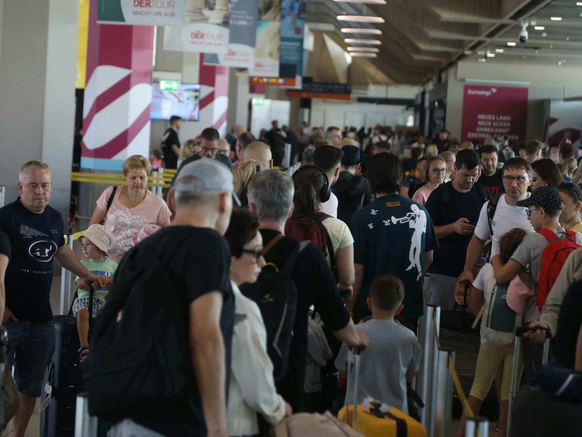 Viele Menschen stehen am Flughafen Köln/Bonn in der Schlange.