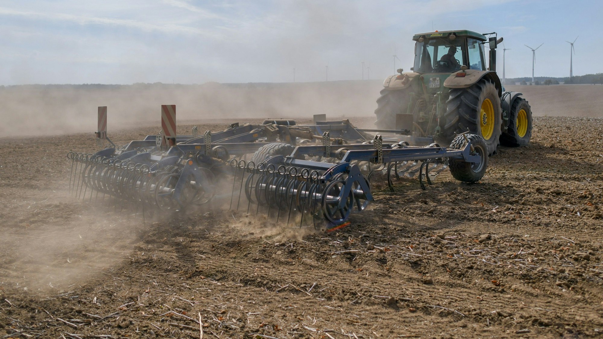 Ein Landwirt bearbeitet mit Traktor und Grubber den trocken Boden auf einem Acker (Archivbild): Eine 14-Jährige ist auf Rügen unter einen Grubber gekommen.