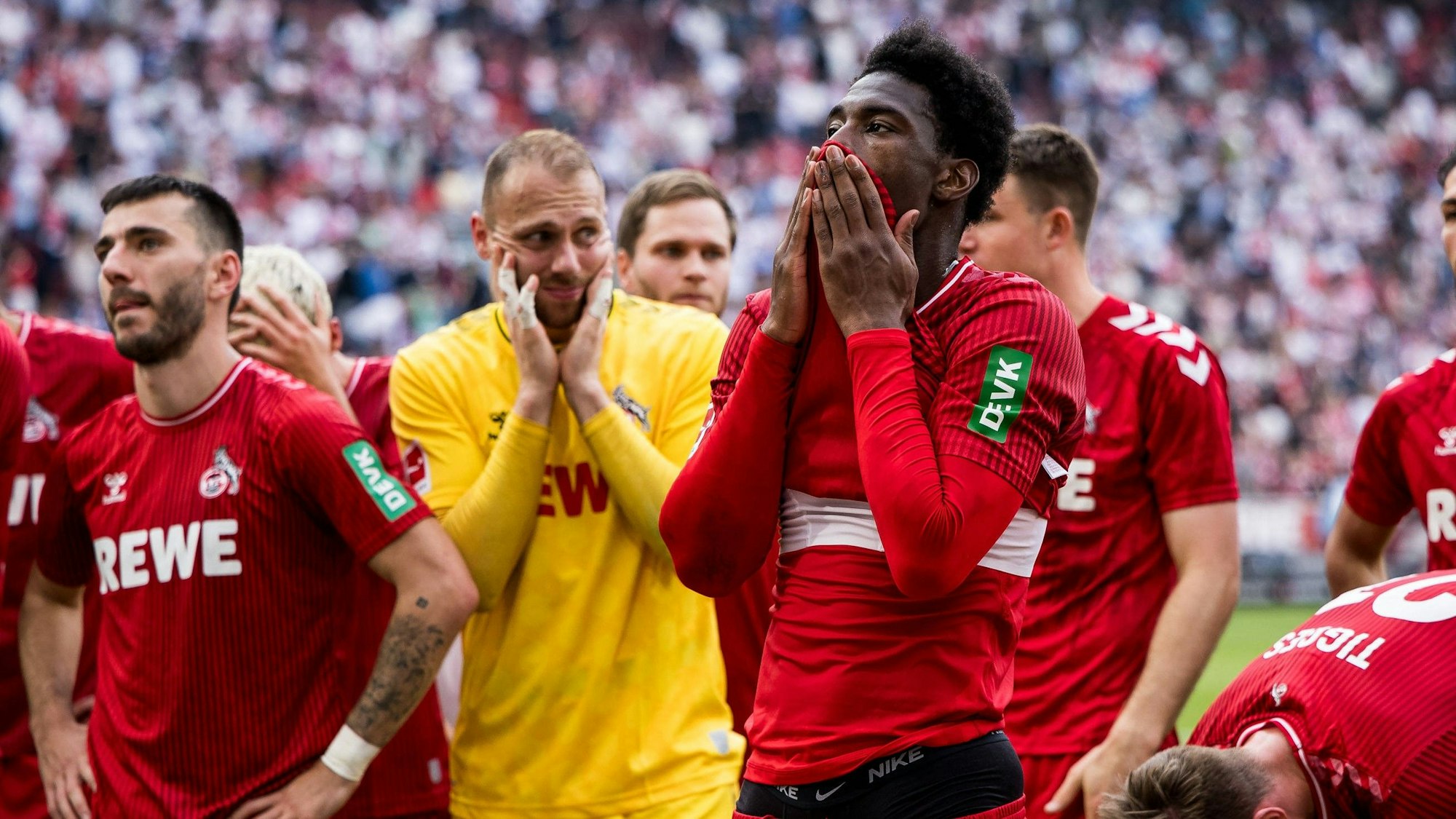 Die Spieler des 1. FC Köln, darunter Faride Alidou stehen nach einem Spiel vor den eigenen Fans.