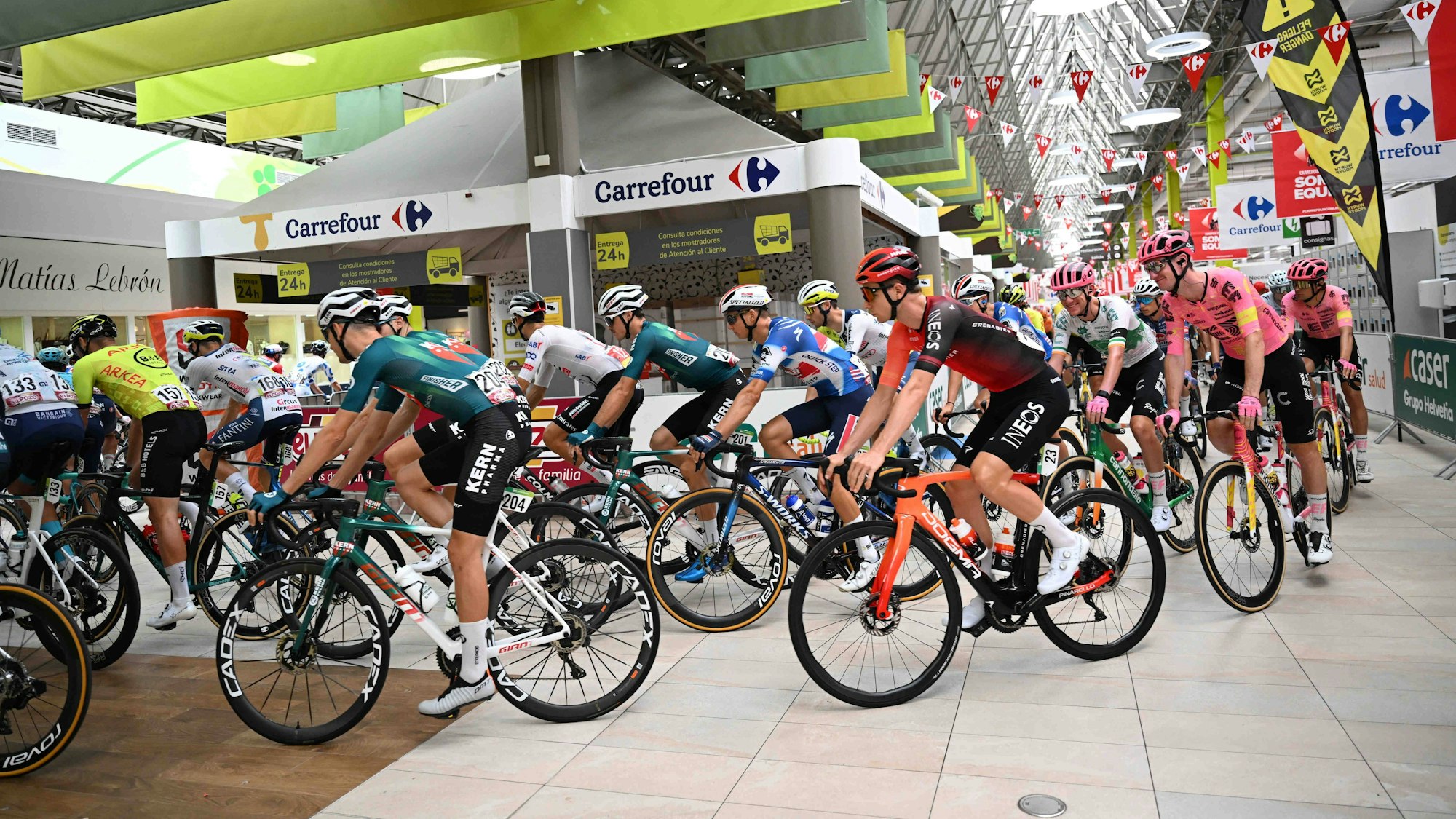 Das Fahrerfeld bei der Vuelta radelt am Donnerstag (22. August 2024) durch einen Supermarkt.