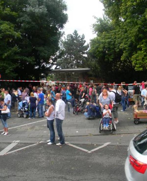 Dutzende Menschen stehen vor dem Kölner Zoo, der evakuiert werden musste.