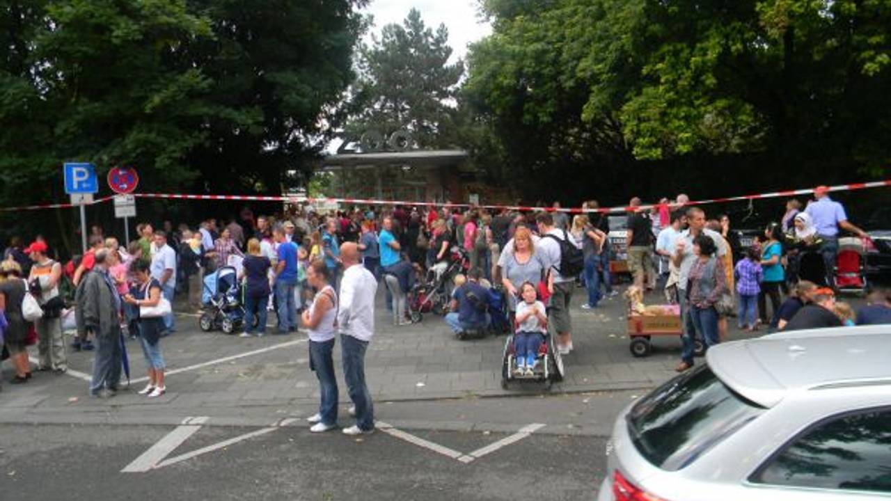 Dutzende Menschen stehen vor dem Kölner Zoo, der evakuiert werden musste.
