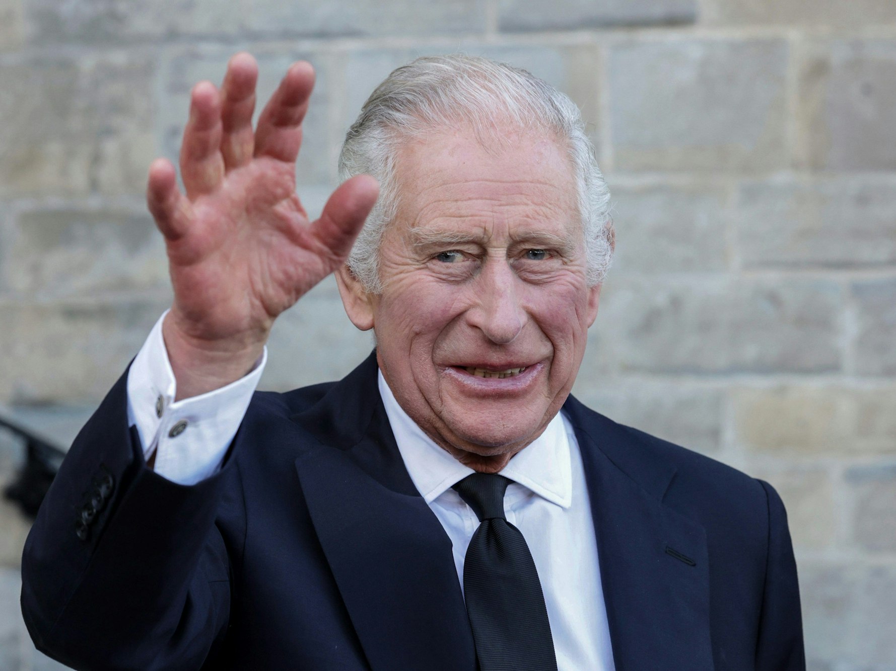 König Charles III. von Großbritannien winkt bei einem Empfang für lokale Wohltätigkeitsorganisationen im Cardiff Castle in Wales.