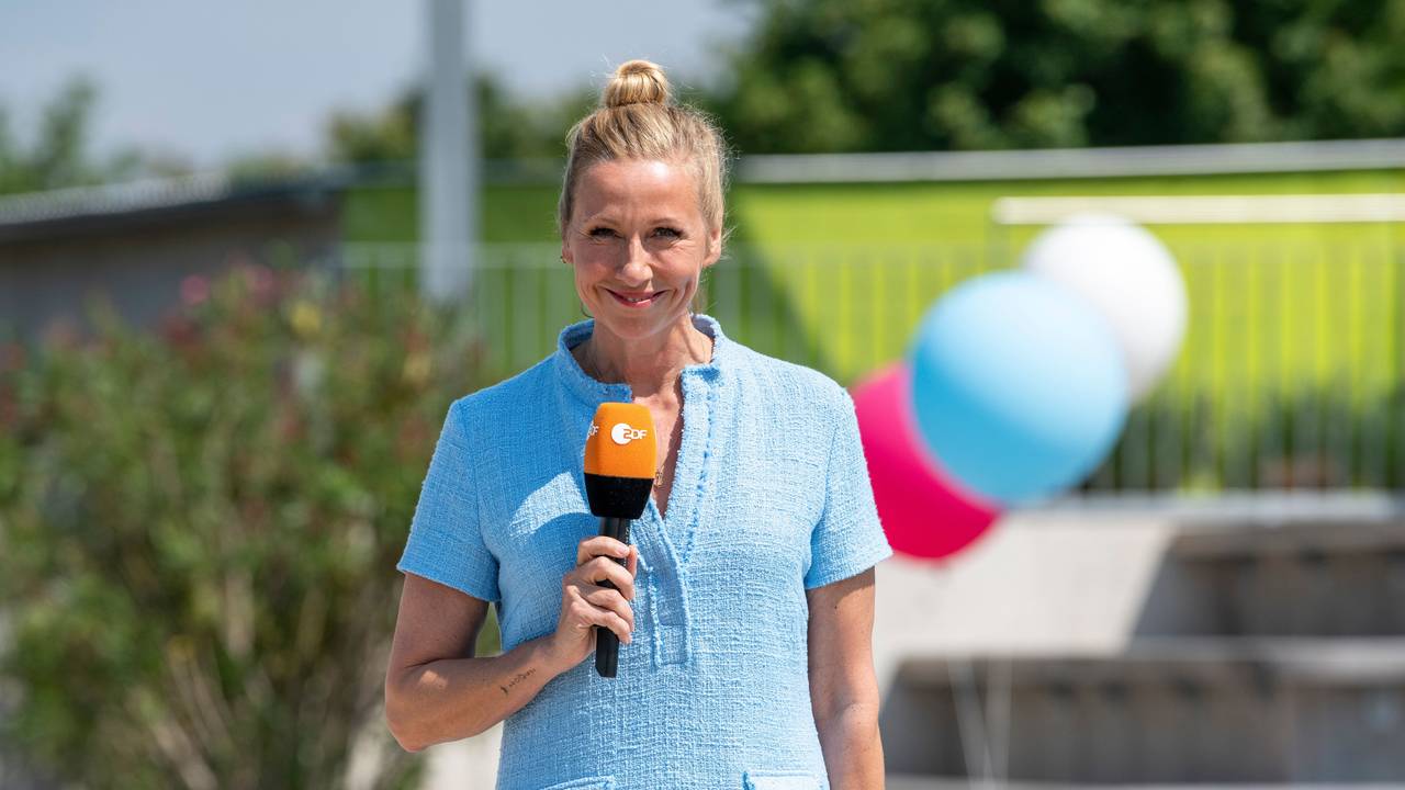 "ZDF-Fernsehgarten: Moderatorin Andrea Kiewel steht im "Fernsehgarten" und lächelt in die Kamera.