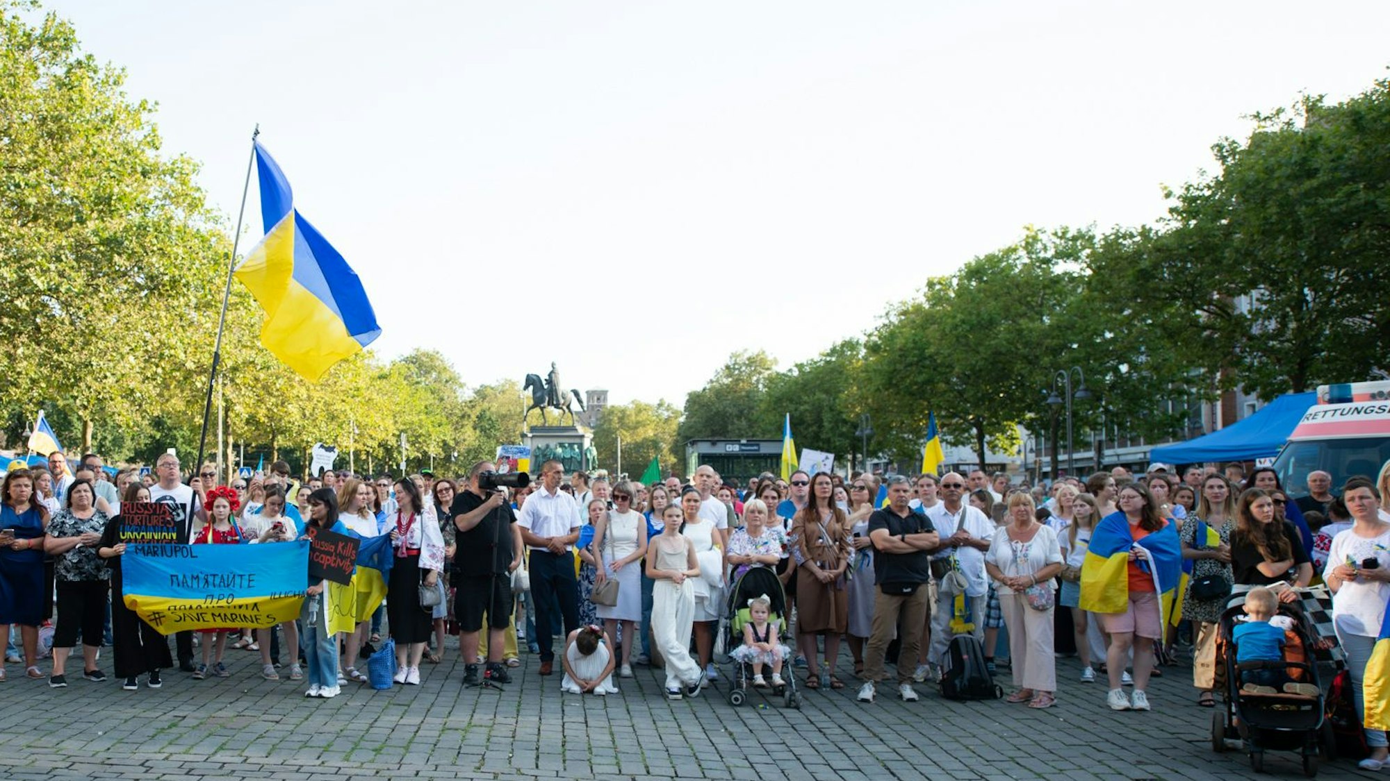 Viele Menschen stehen auf dem Heumarkt in Köln und schauen für ein Gruppenfoto in die Kamera.
