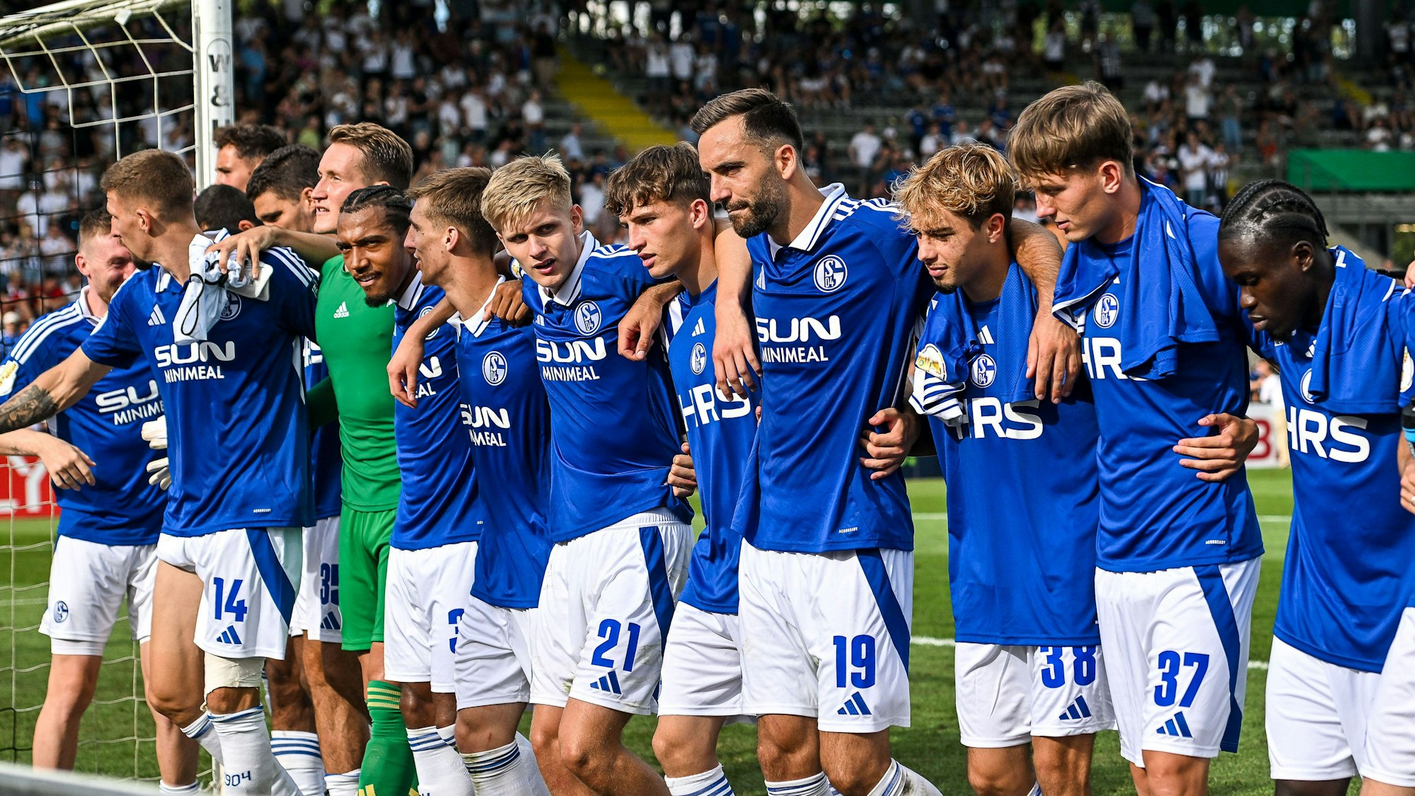 Schalker Mannschaft steht nach dem DFB-Pokalsspiel gegen den VfR Aalen gemeinsam vor den mitgereisten Anhängern.