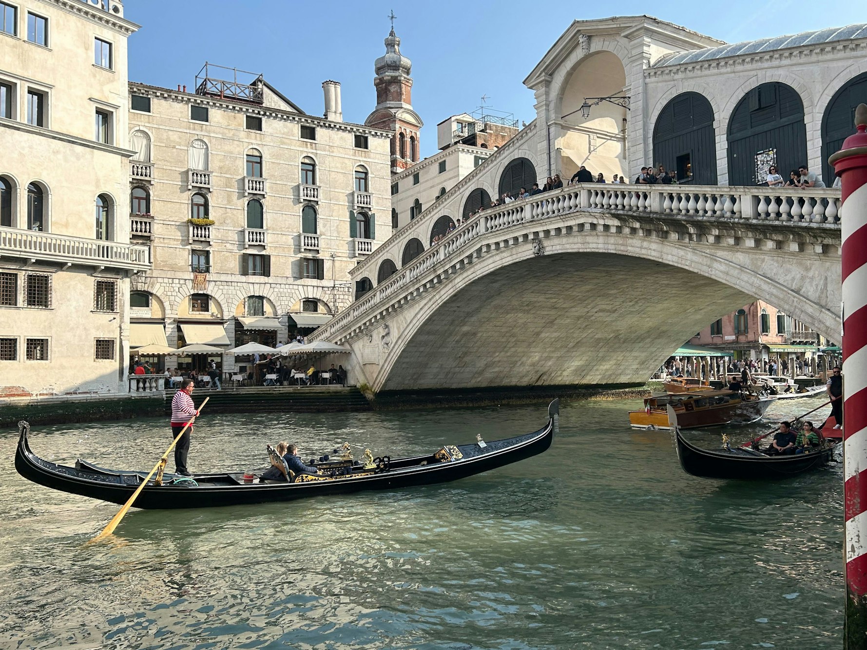 Eine Gondel mit Touristen vor der Rialto-Brücke im Zentrum von Venedig.