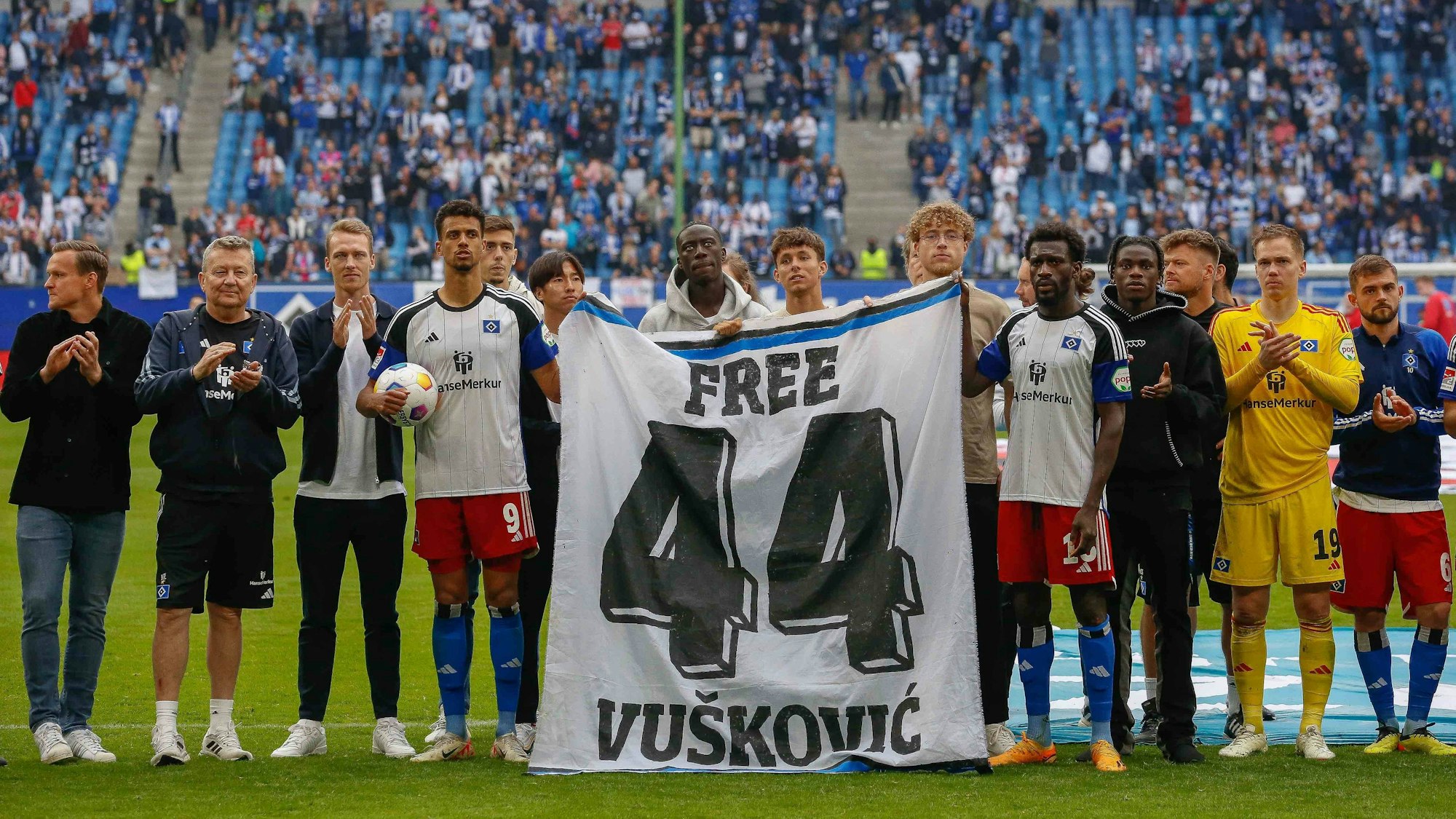 Die Mannschaft des Hamburger SV hält nach dem Ligaspiel gegen den 1. FC Nürnberg ein Free-Vuskovic-Banner hoch.