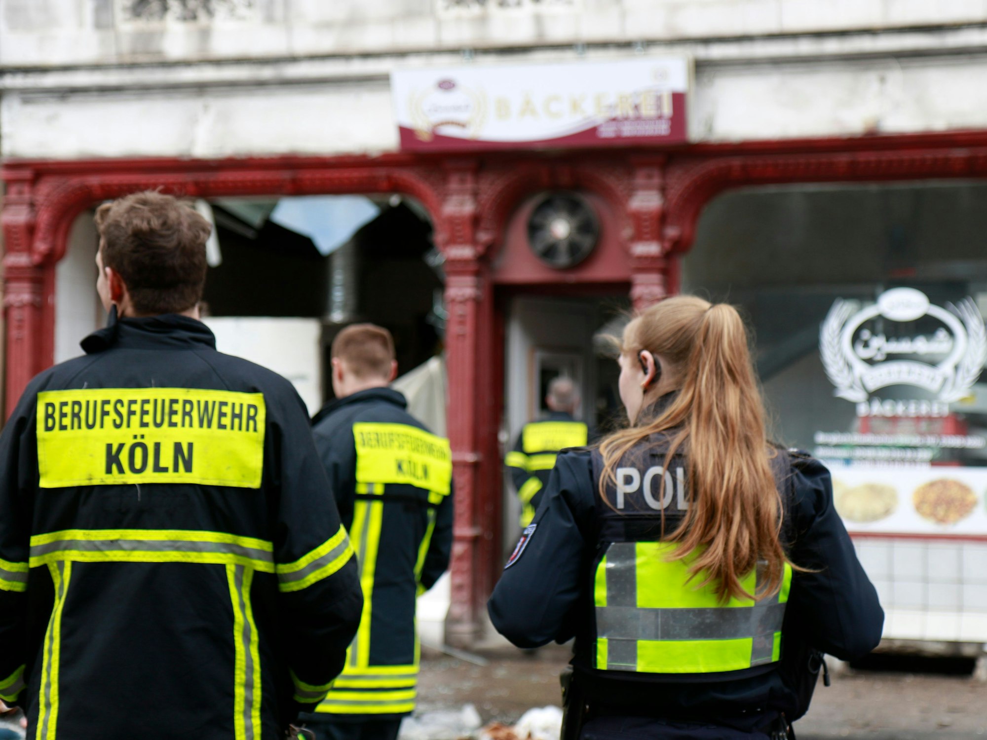 Polizei und Feuerwehr Köln befindet sich an einem Einsatzort und sind von hinten zu sehen.