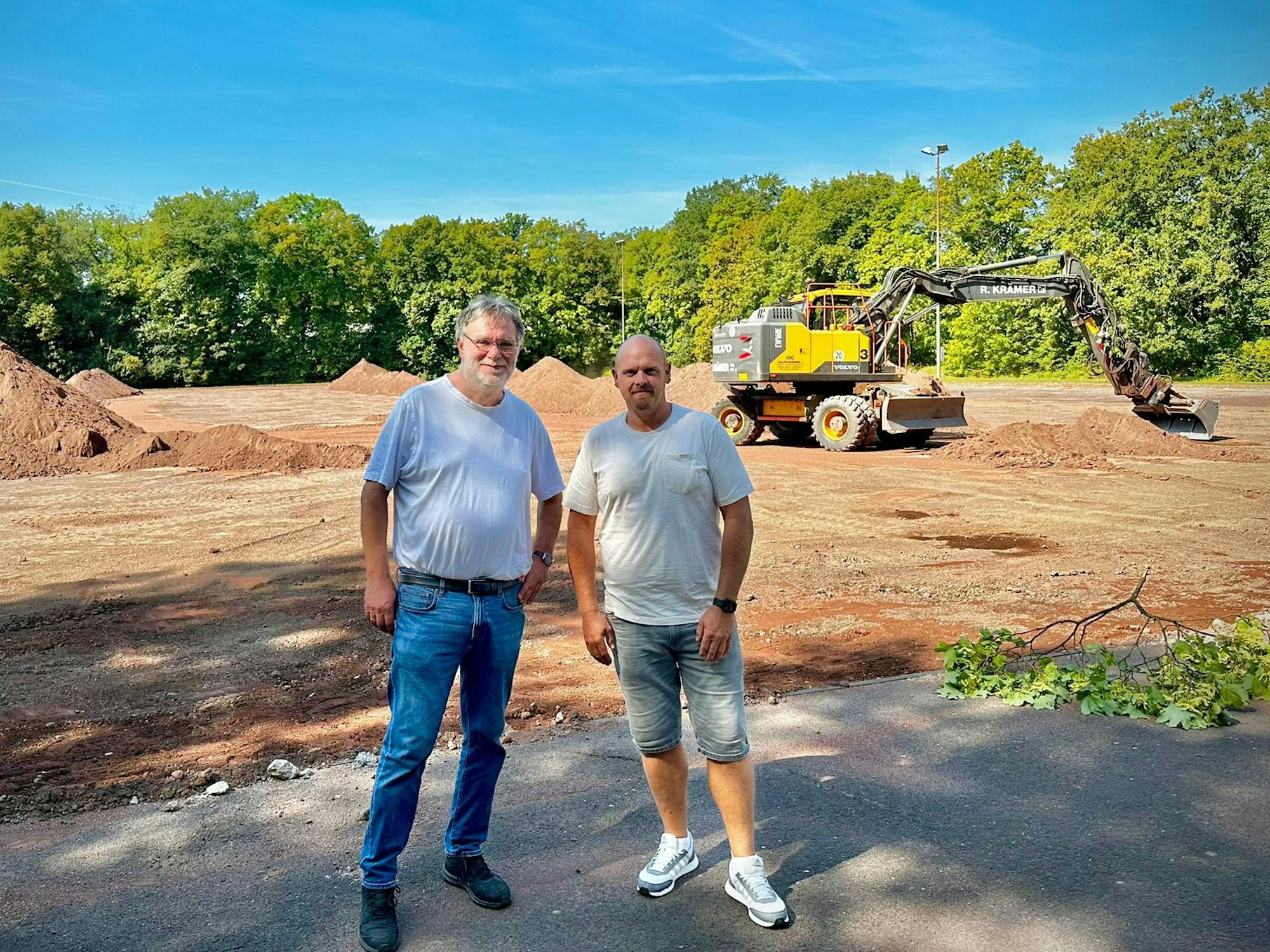 Präsident Hans-Georg Offermann (l.) und Abteilungsleiter Mario Petrovic stehen am Dienstag (27. August 2024) vor dem Sportplatz des RSV Rath-Heumar, der derzeit zum Kunstrasenplatz umgebaut wird.