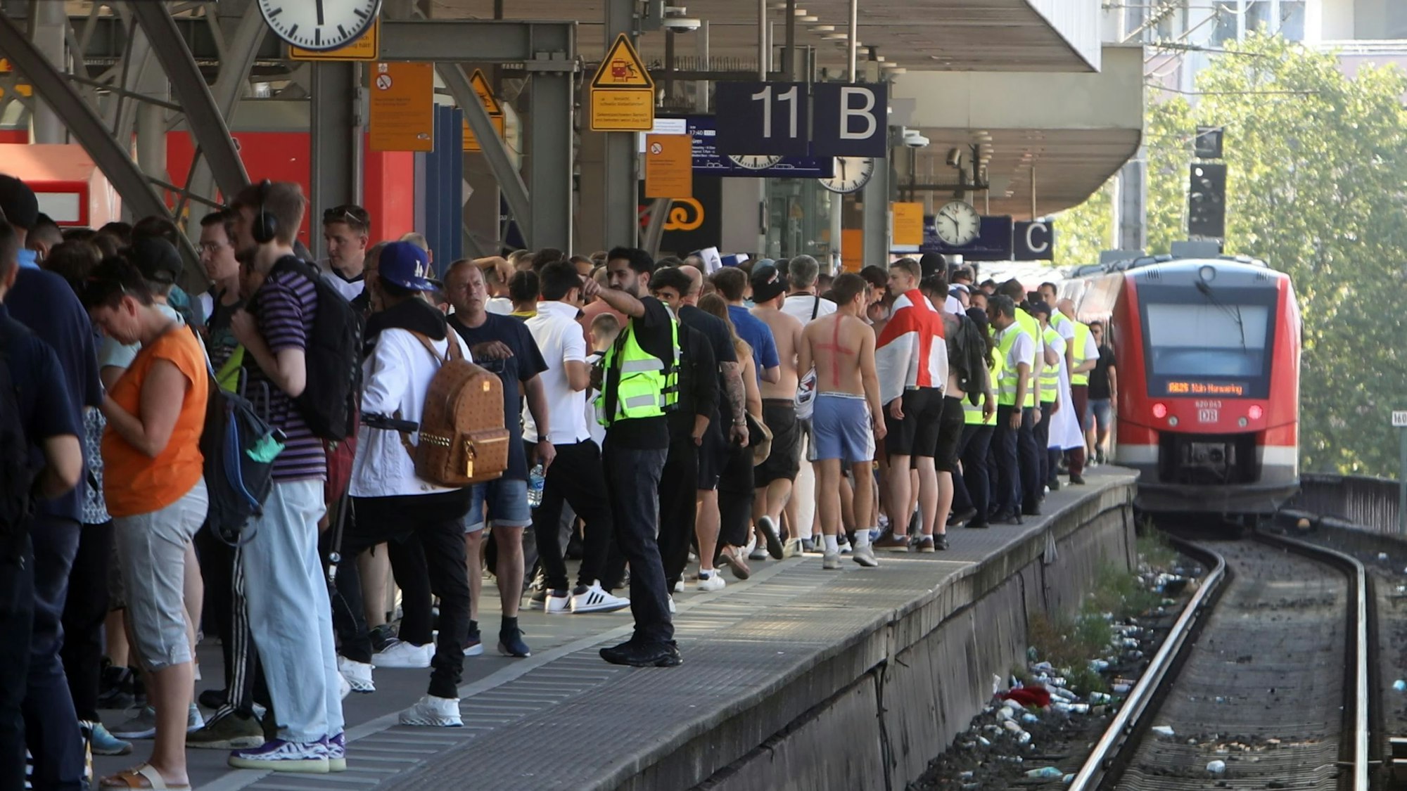 Fußball-Fans stehen während der EM 2024 an einem Bahnsteig in Köln.