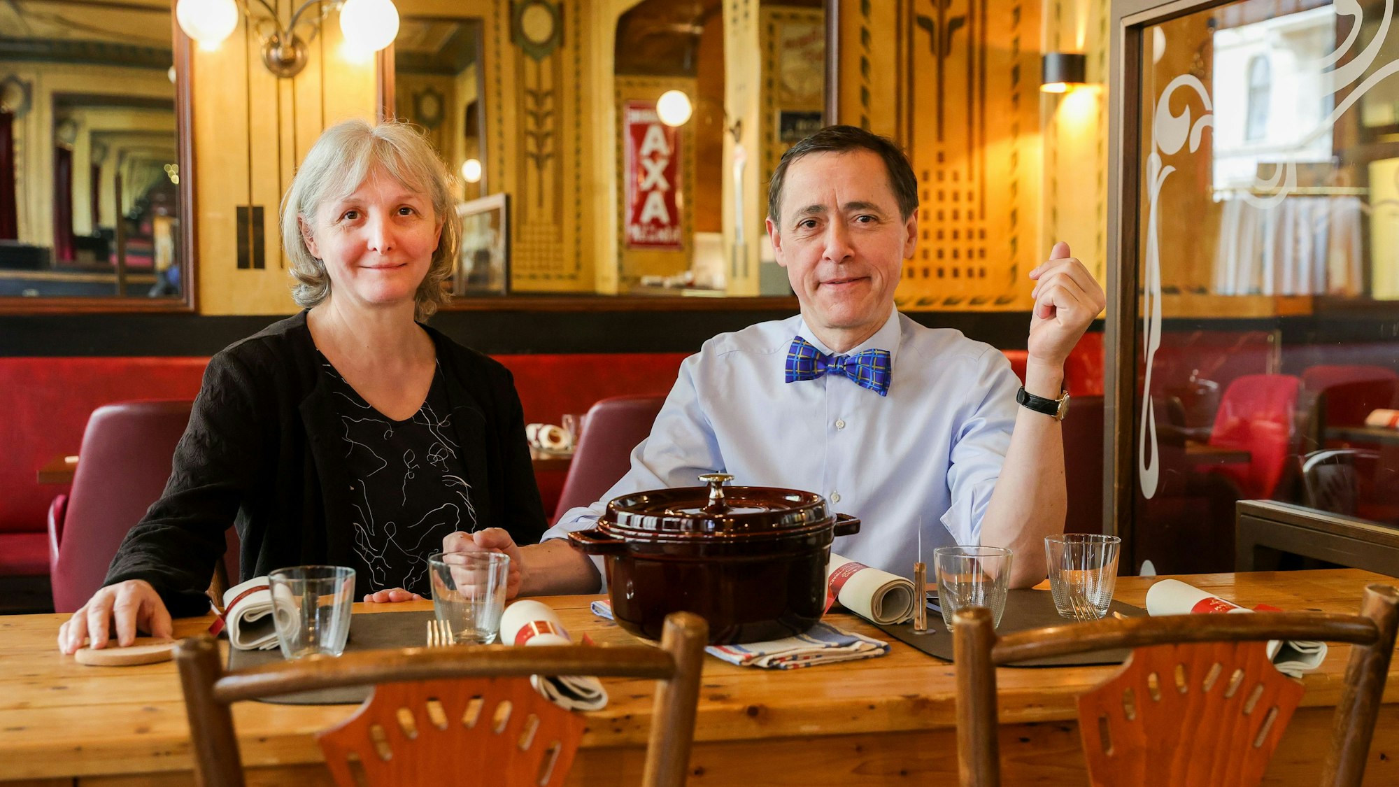 Die Inhaber Liliane Moissonnier und Vincent Moissonnier sitzen an einem Tisch in ihrem Bistro.