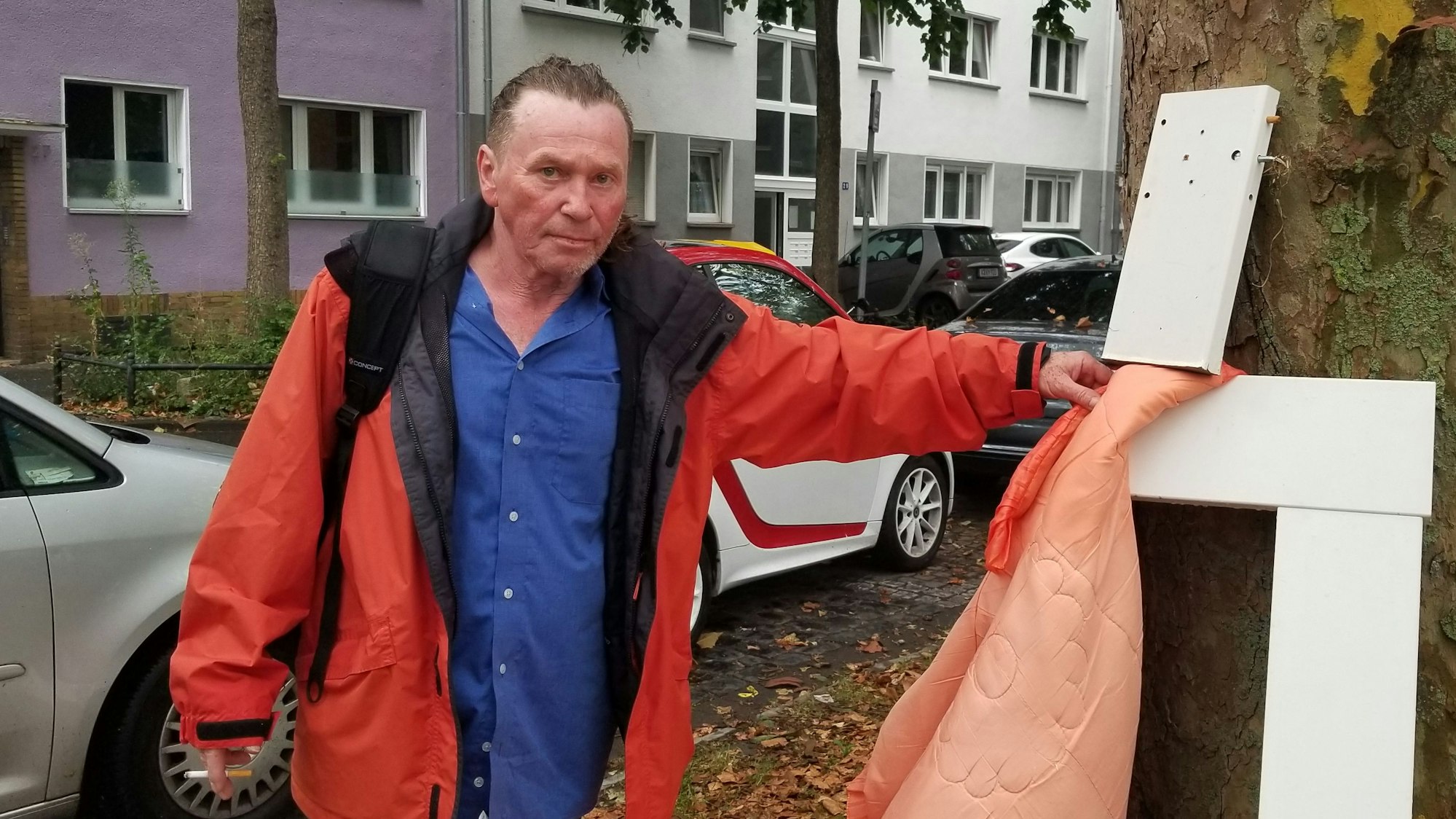 Ein Mann mit Müll in der Hand steht im Kölner Stadtteil Humboldt-Gremberg.