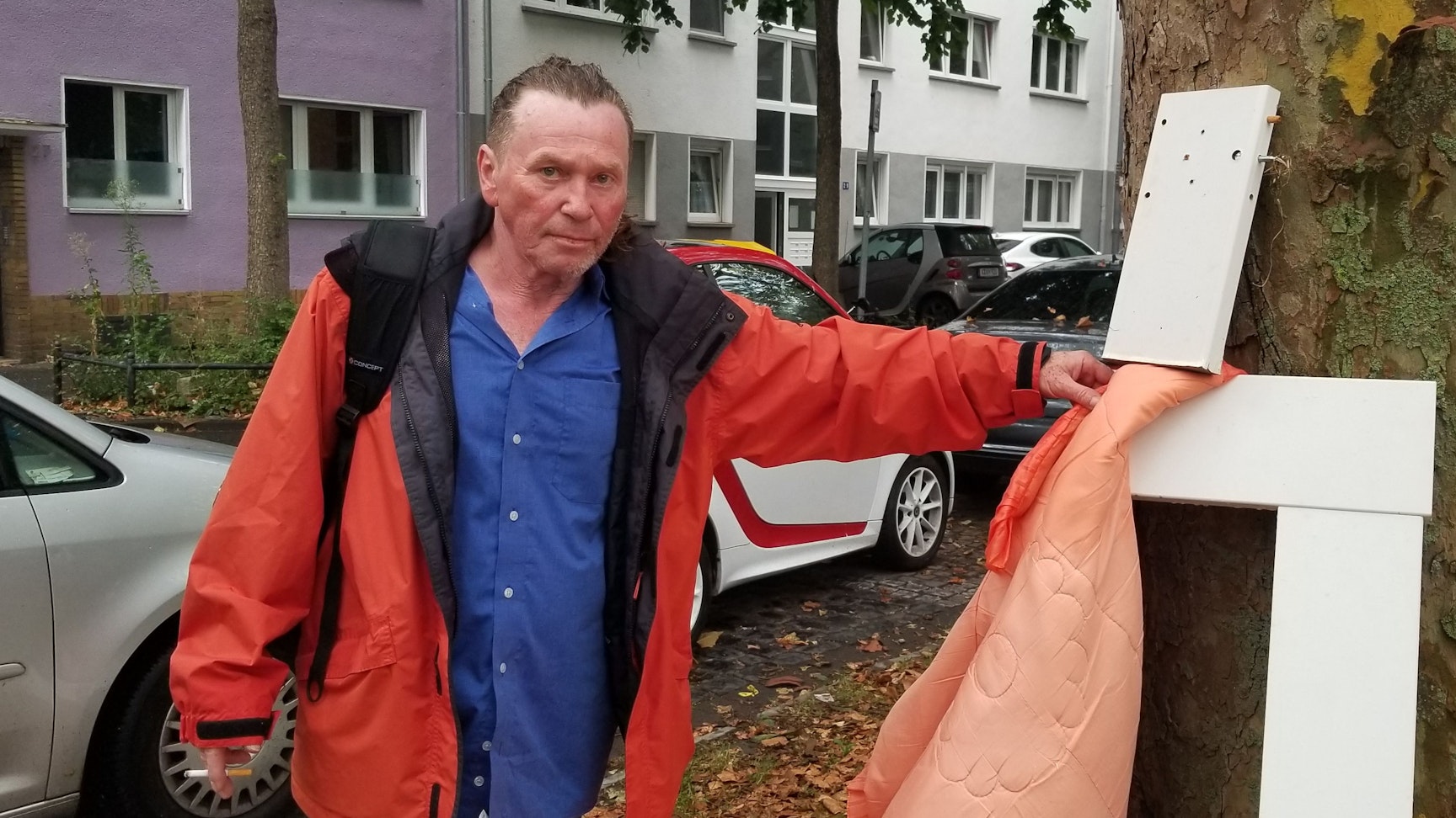 Ein Mann mit Müll in der Hand steht im Kölner Stadtteil Humboldt-Gremberg.