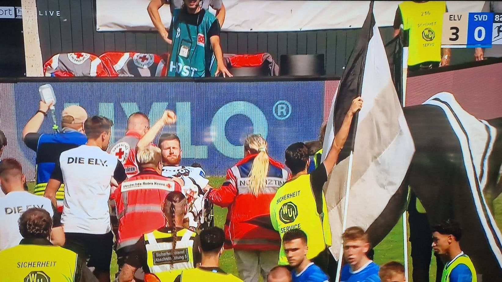 Florian Le Joncour wird vom Platz abtransportiert und reckt die Faust nach oben.