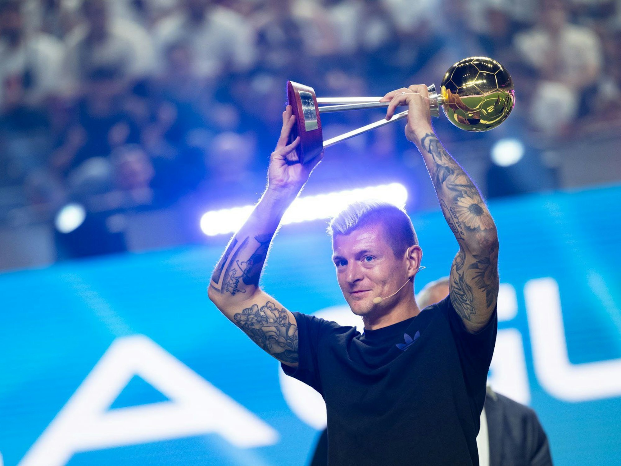 Toni Kroos, Gründer der Icon League, hält während der Eröffnung die Trophäe für den Fußballer des Jahres in die Höhe.