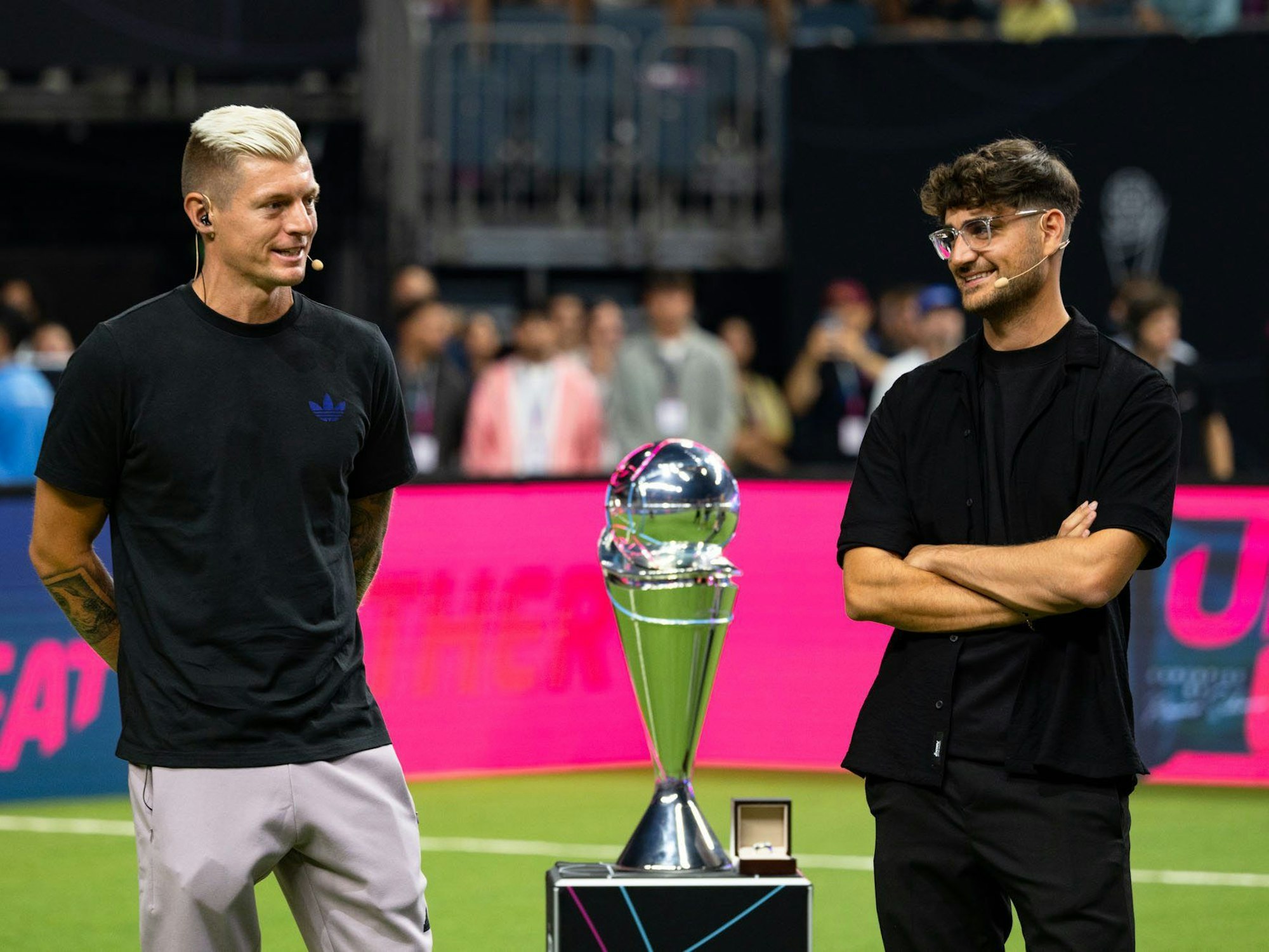 Toni Kroos (l.) und Elias Nerlich, Gründer der Icon League, stehen während der Eröffnung neben dem Ligapokal.
