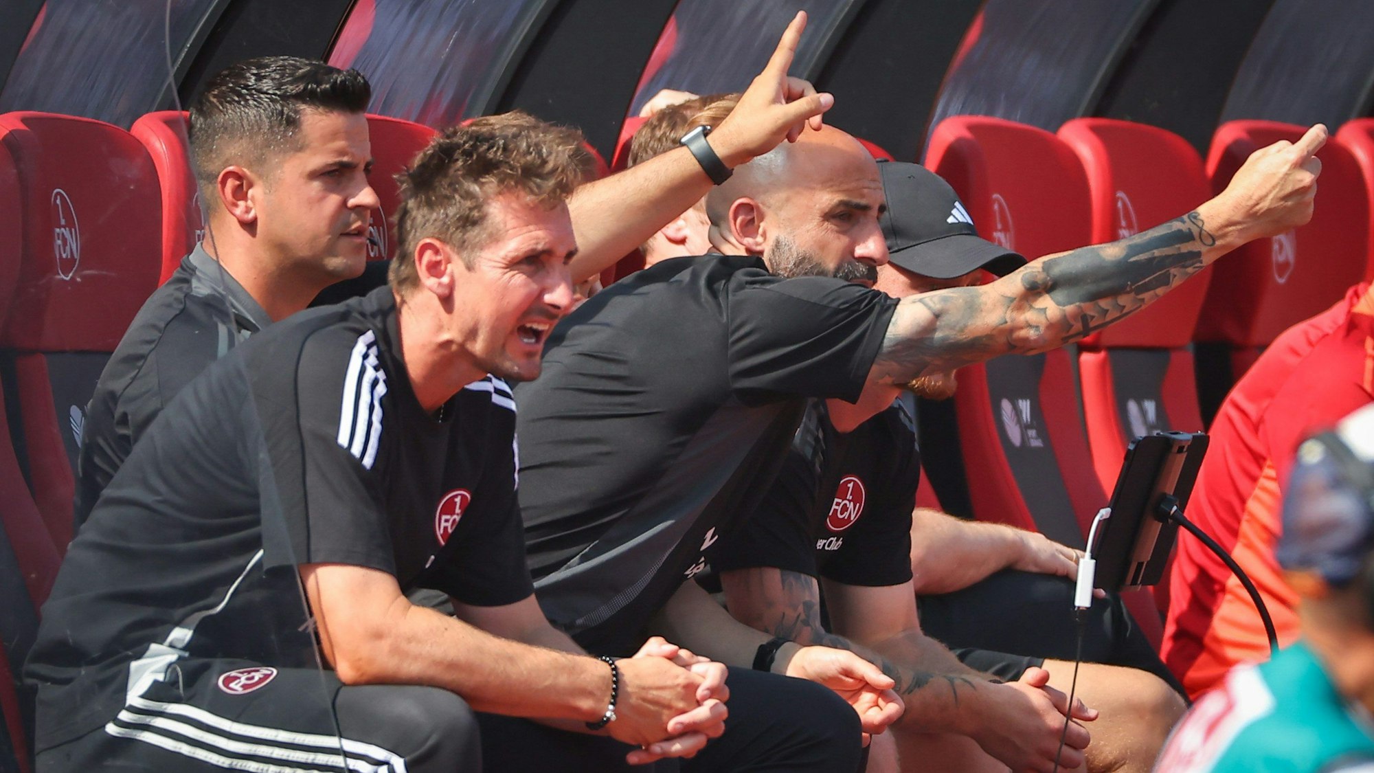 Der Nürnberger Trainer Miroslav Klose (vorn) verfolgt den Spielverlauf von der Bank.