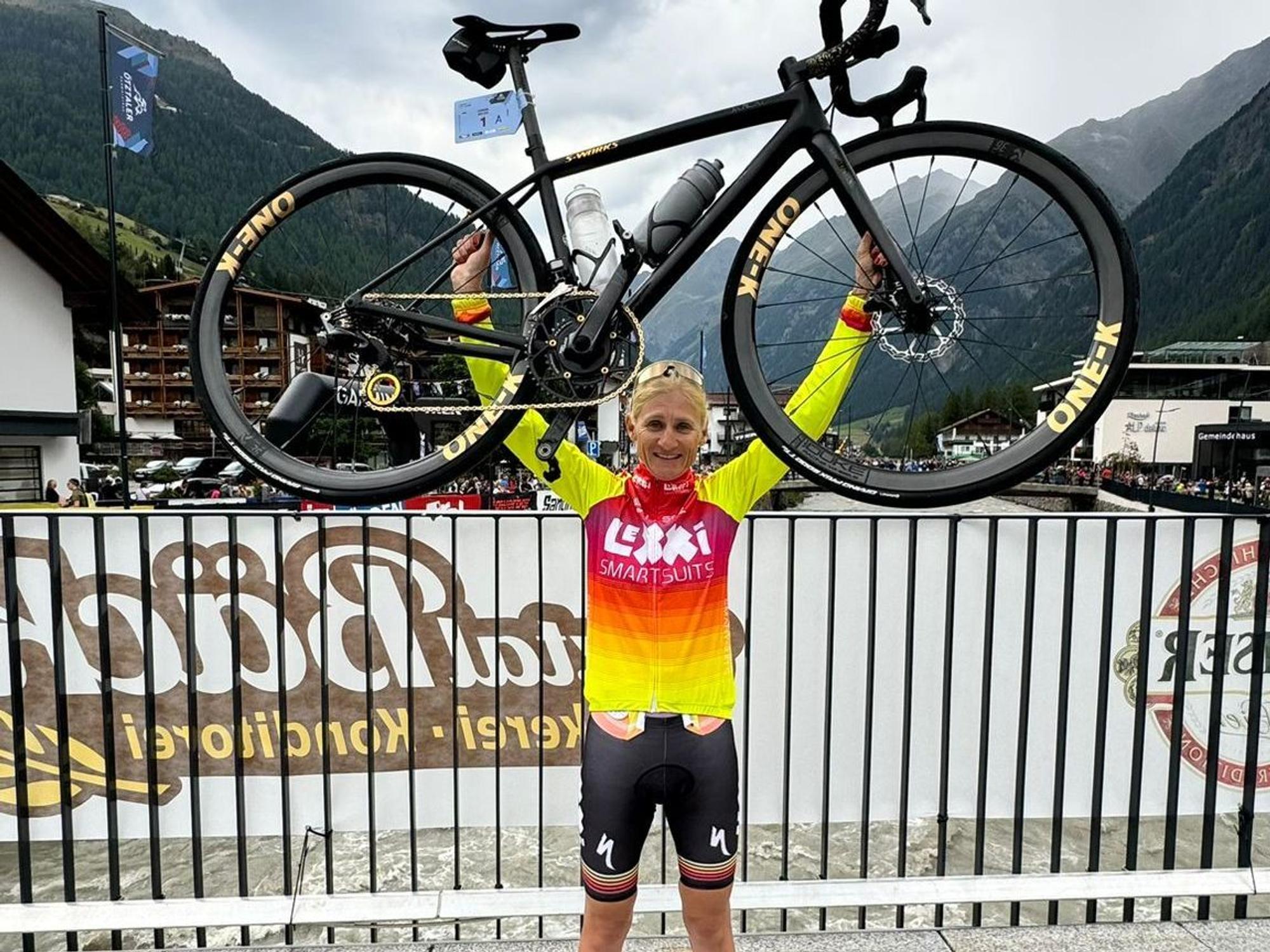 Janine Meyer jubelt mit ihrem Fahrrad und hält es in die Höhe.
