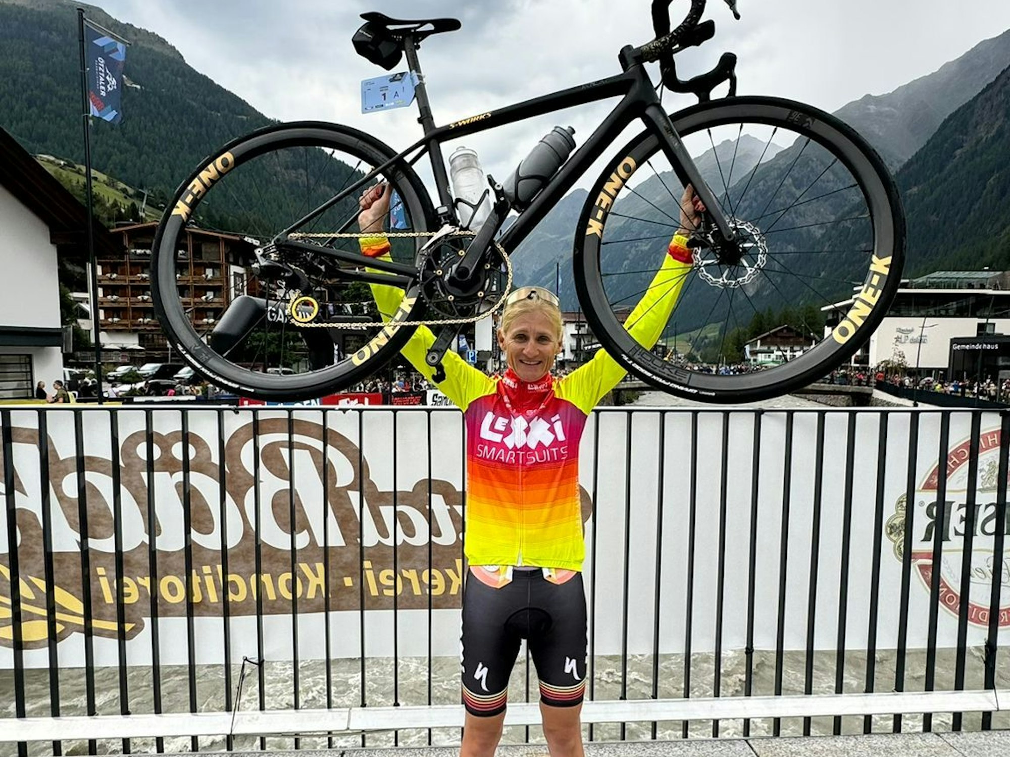 Janine Meyer jubelt mit ihrem Fahrrad und hält es in die Höhe.