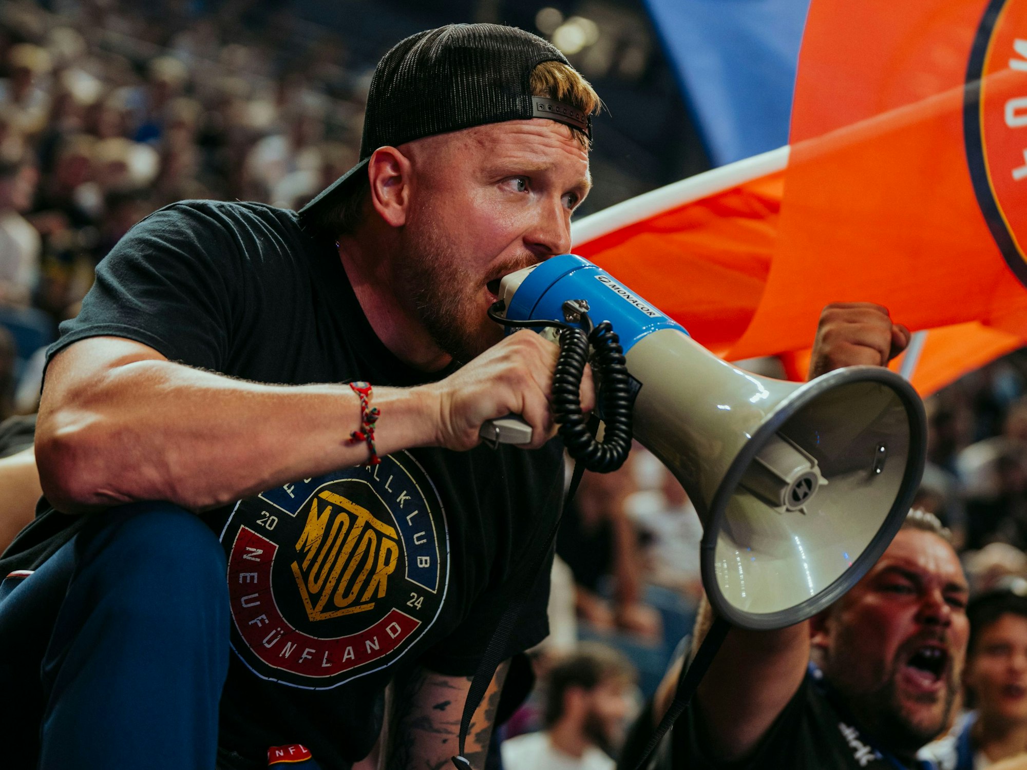 Finch mit Megafon im Fanblock.