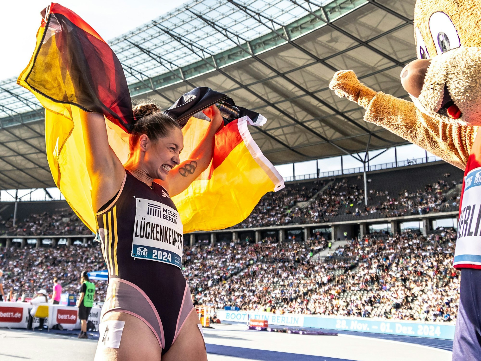 Gina Lückenkemper feierte beim ISTAF mit Deutschland-Flagge und Maskottchen Berlino.