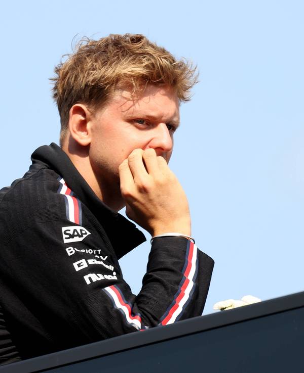 Mick Schumacher fasst sich ins Gesicht und blickt grimmig.