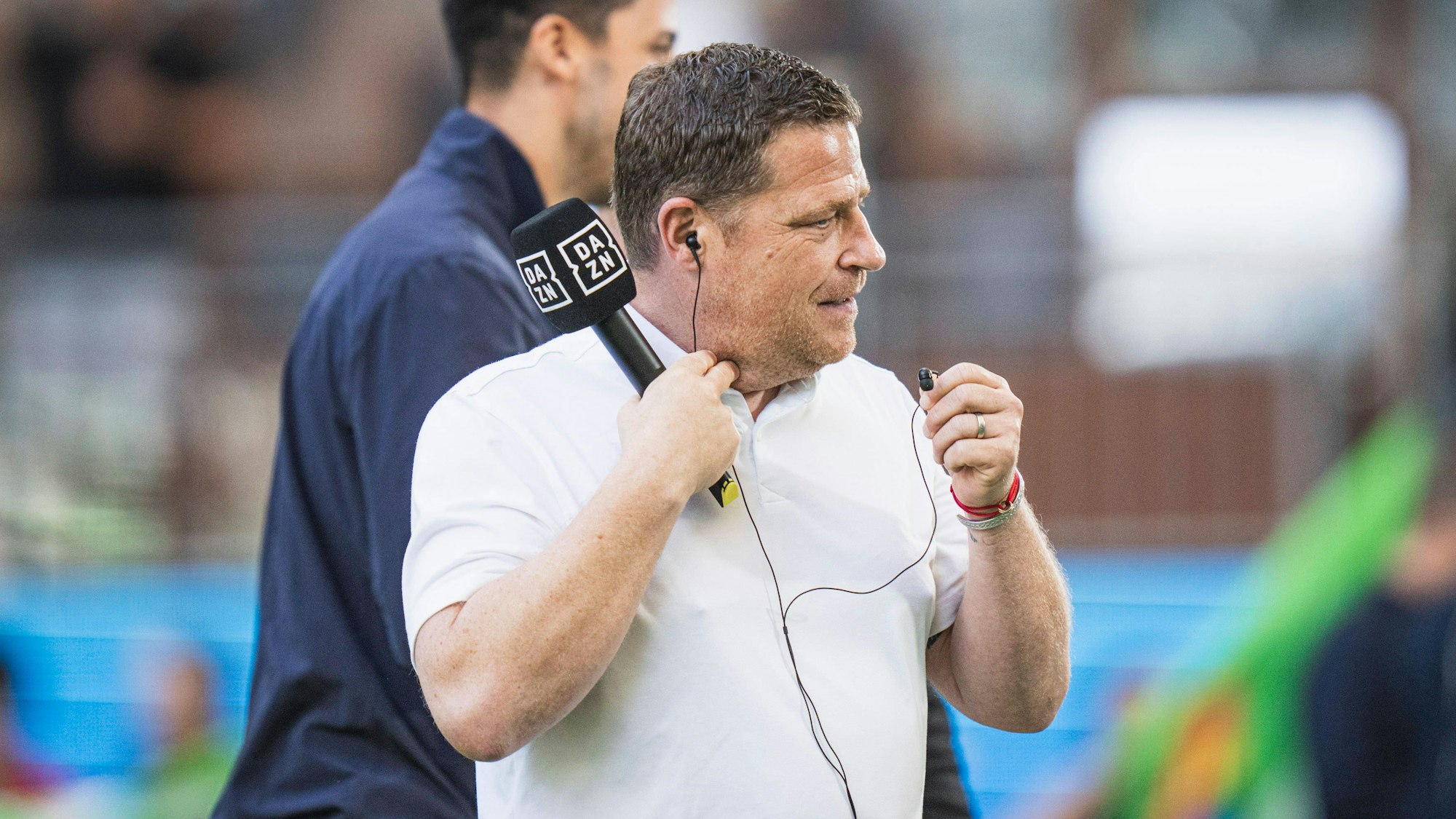 Max Eberl hält nach einem TV-Interview bei einem Spiel des FC Bayern noch das Mikrofon in der Hand.
