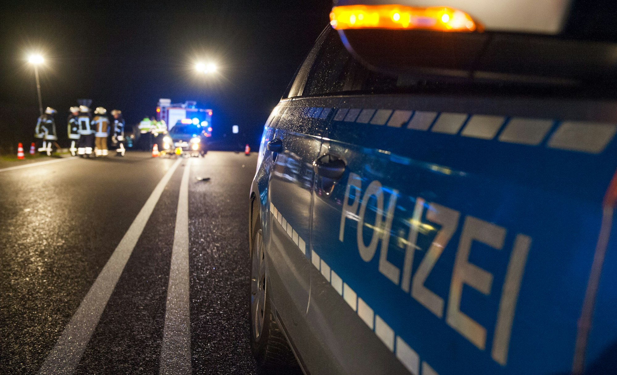 Streifenwagen der Polizei stehen auf einer Bundesstraße.